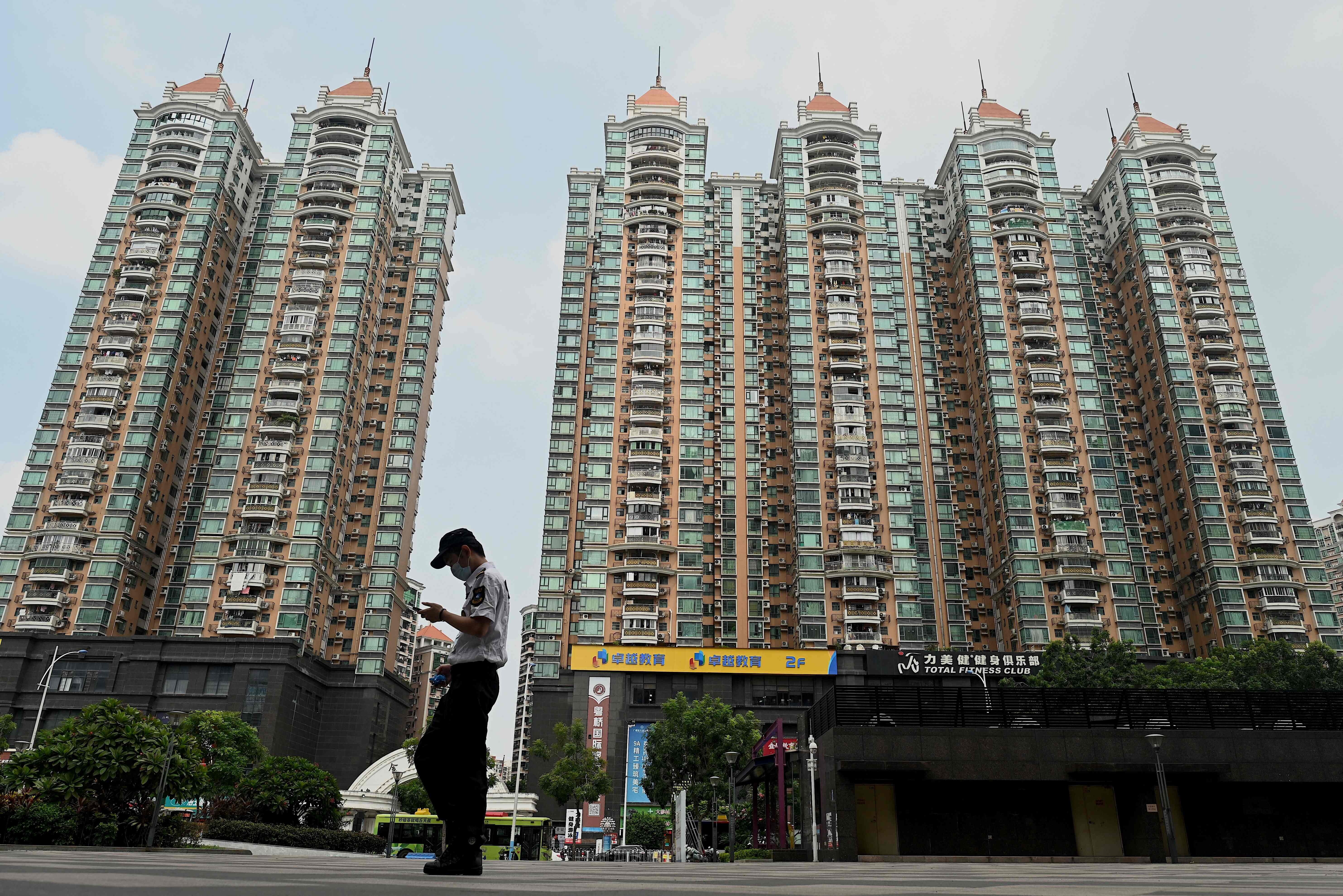 This file photo taken on September 17, 2021 shows a man walking past a housing complex by Chinese property developer Evergrande in Guangzhou. Photo: AFP