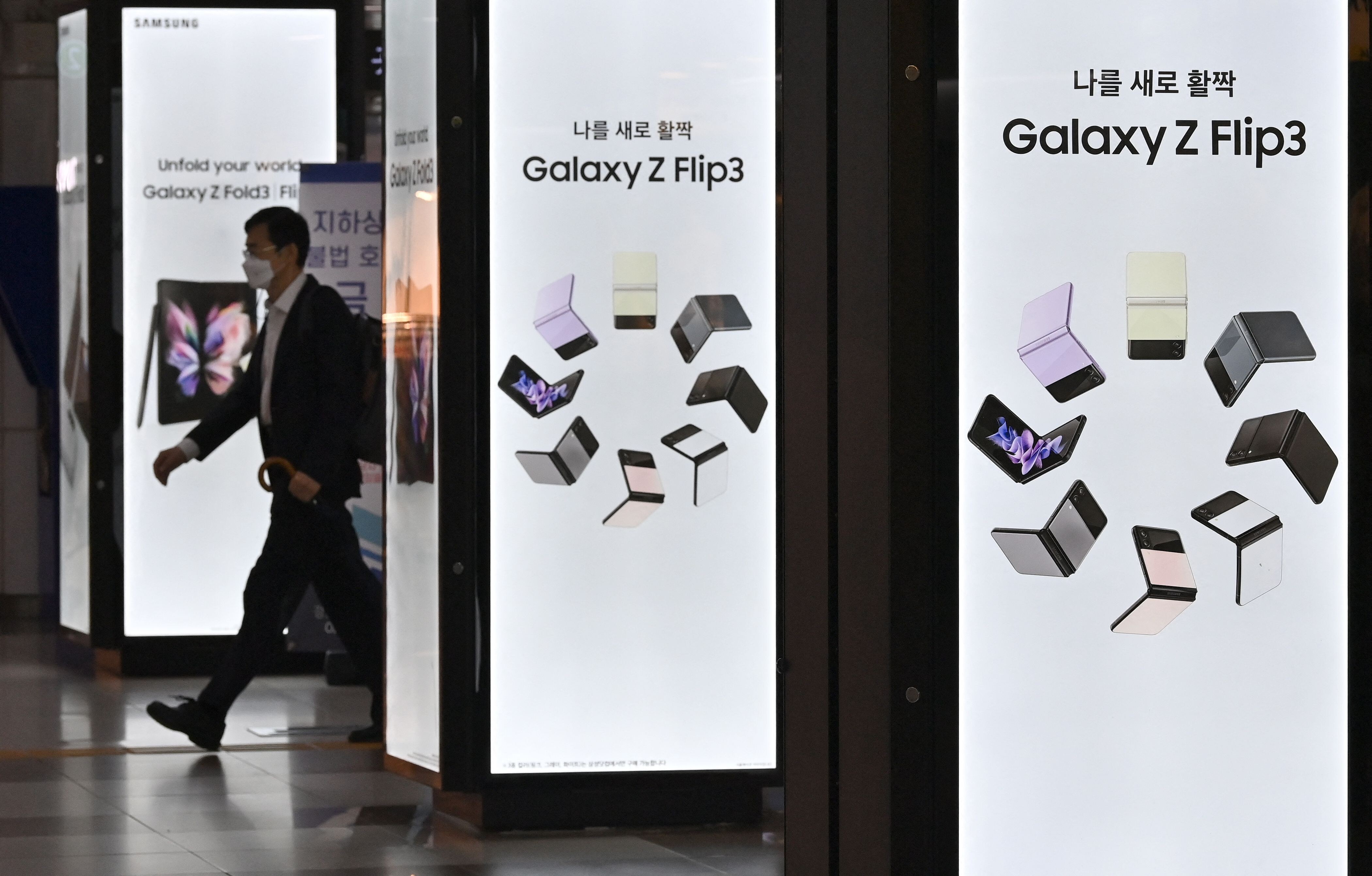 A man walks past an advertisement for Samsung Electronics’ Galaxy Z Fold3 and Flip3 smartphones at an underground shopping area in Seoul, South Korea, on October 8, 2021. Photo: Agence France-Presse