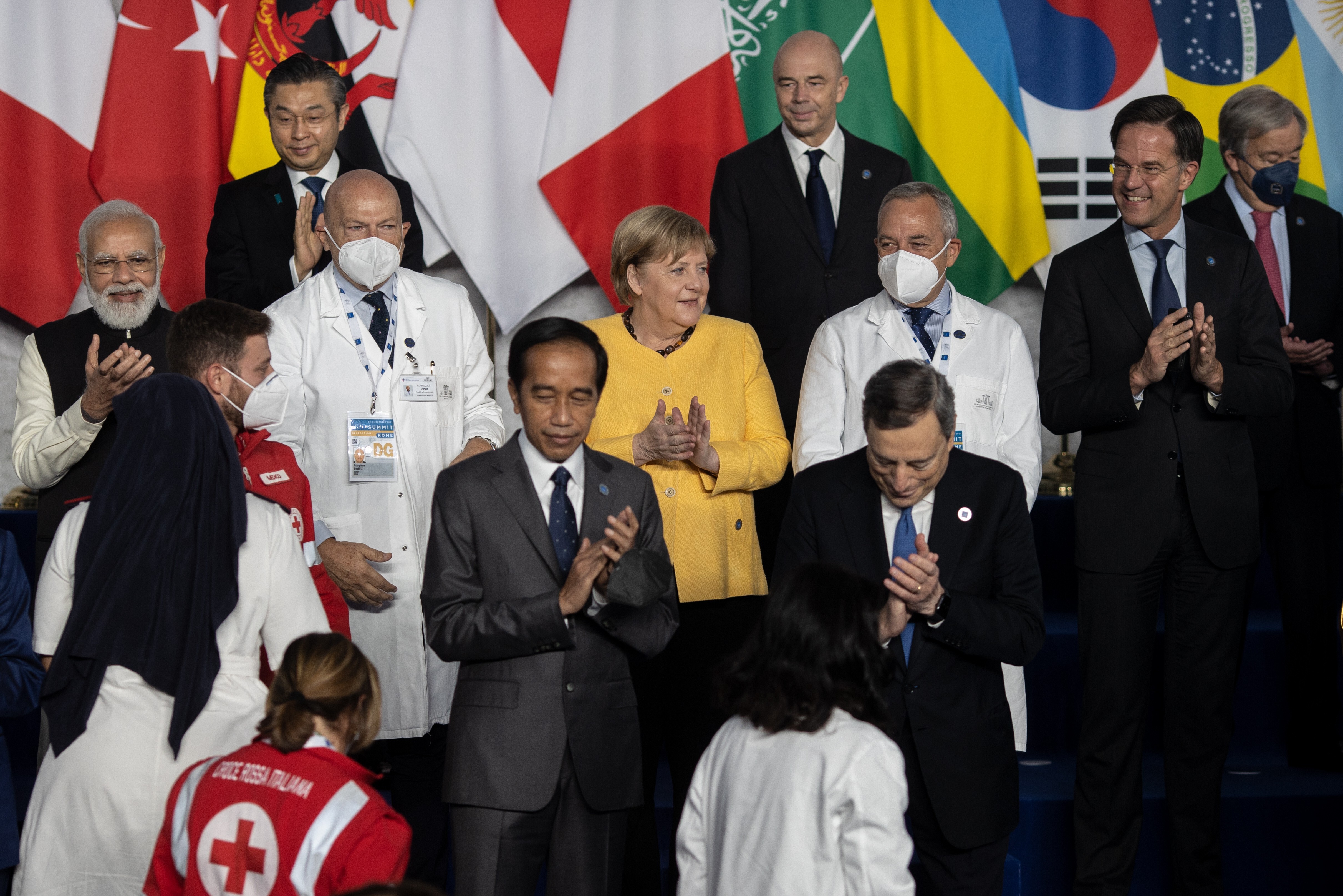 Indian Prime Minister Narendra Modi (left), German Chancellor Angela Merkel (centre), Dutch Prime Minister Mark Rutte (right), Italian Prime Minister Mario Draghi and Indonesian President Joko Widodo applaud Italian health care workers as they gather for the official family photo on day one of the G20 World Leaders Summit at Rome Convention Centre. Photo: DPA