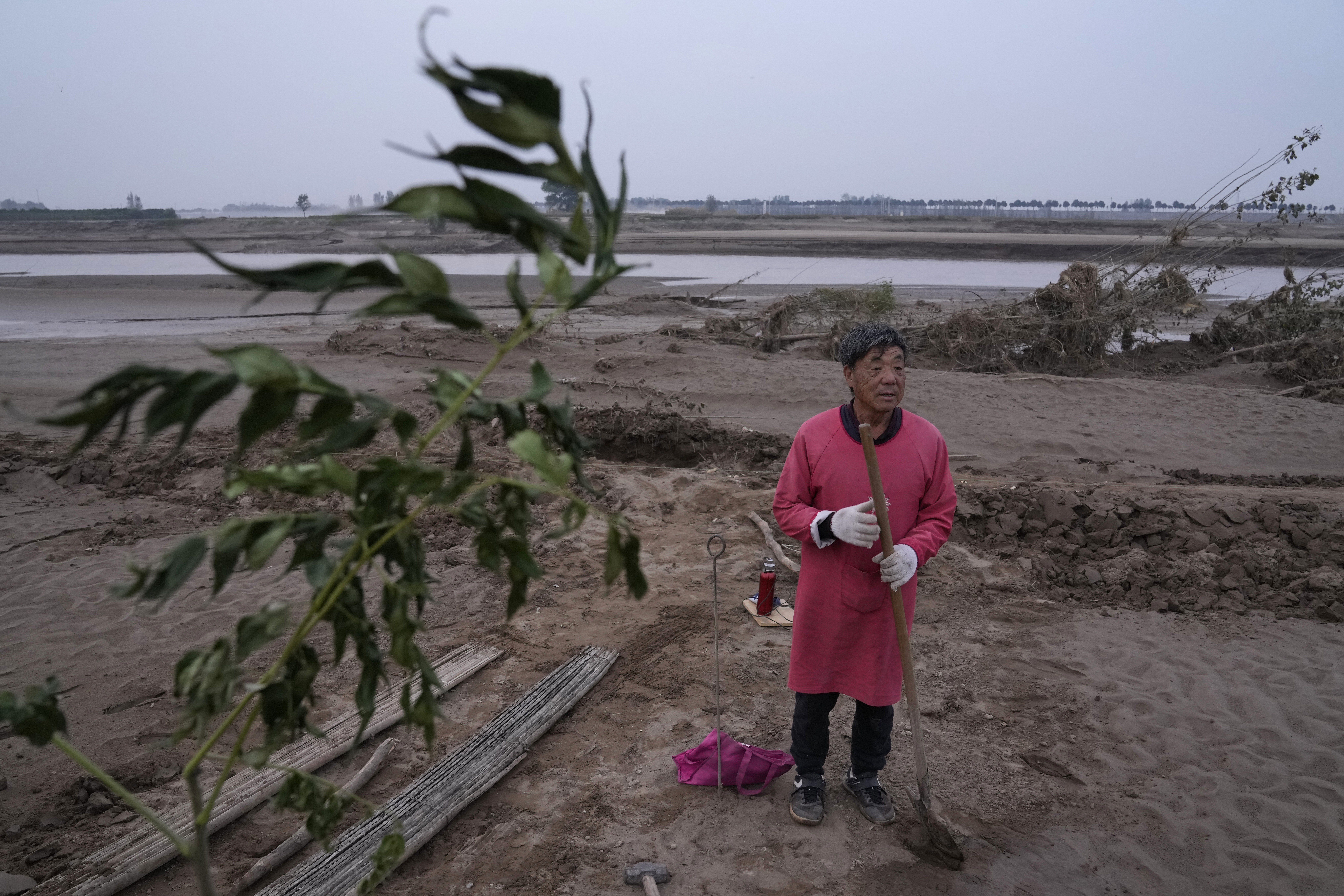 Wang Yuetang stands near what used to be his peanut farm – near Xubao village in Henan – before torrential rains submerged the lowland leaving him with no summer harvest. Photo: AP
