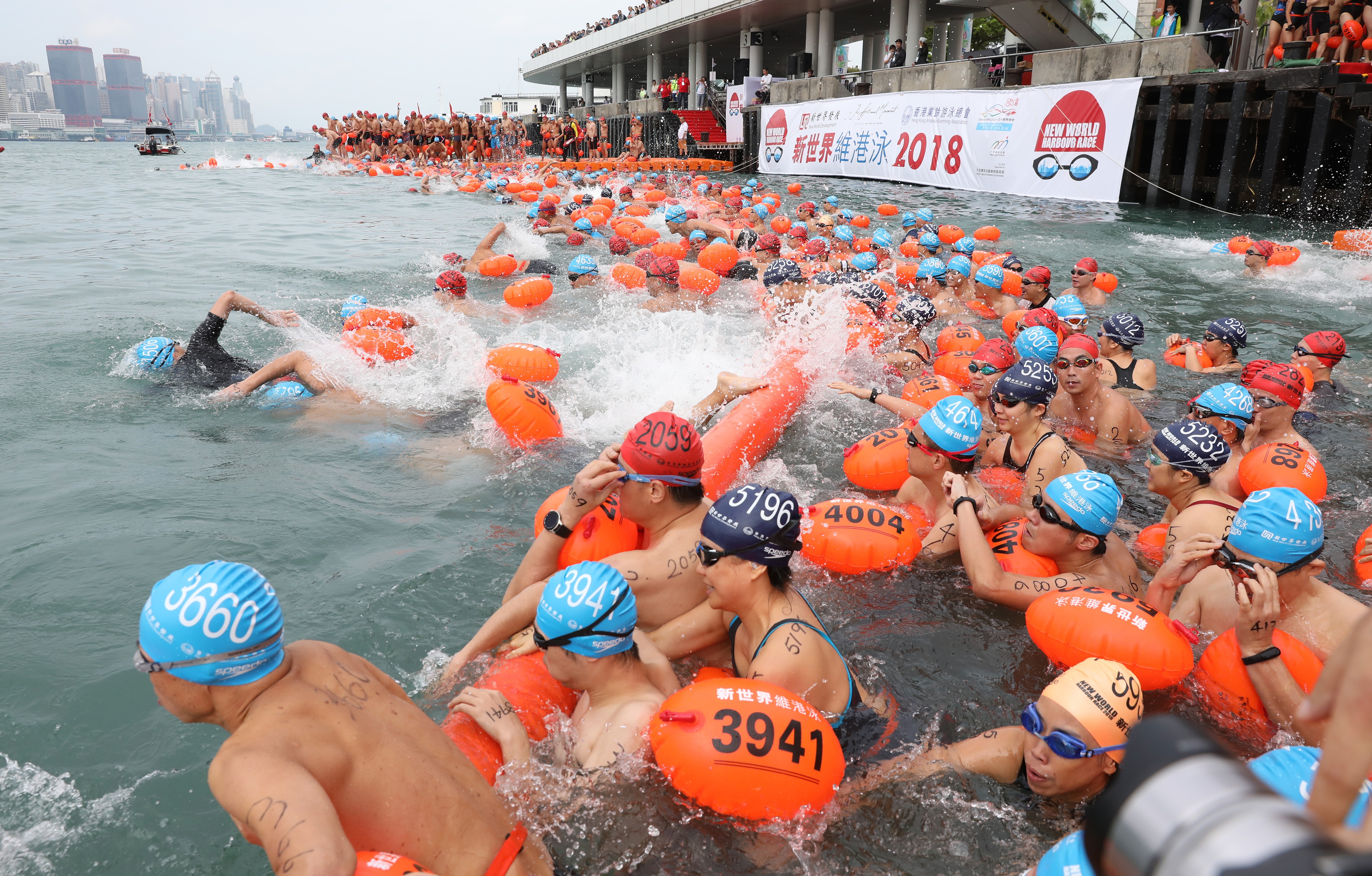 Swimmers swim across Victoria Harbour from Tsim Sha Tsui to Wan Chai Golden Bauhinia Square Public Pier during the 2018 New World Harbour Race, when it was last held. Photo: Robert Ng