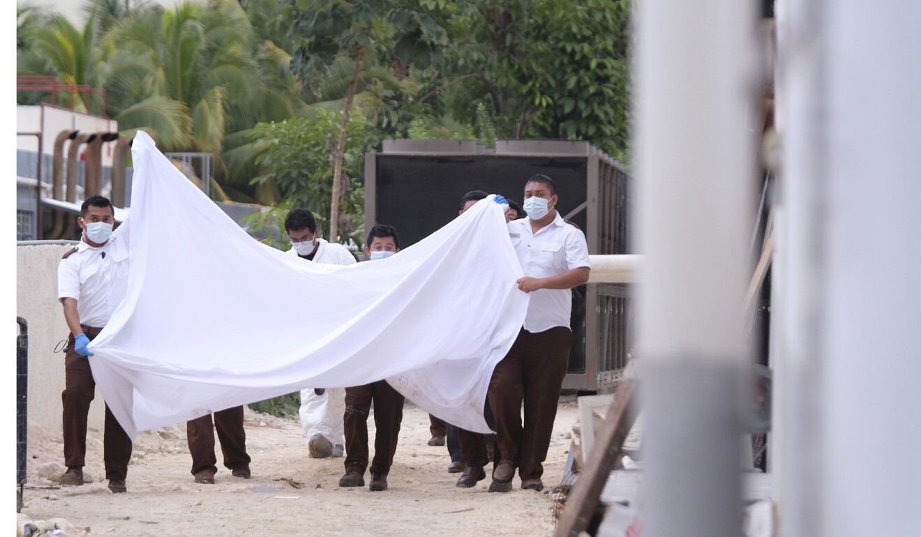 Police hold a blanket in an attempt to block onlookers. Photo: AP