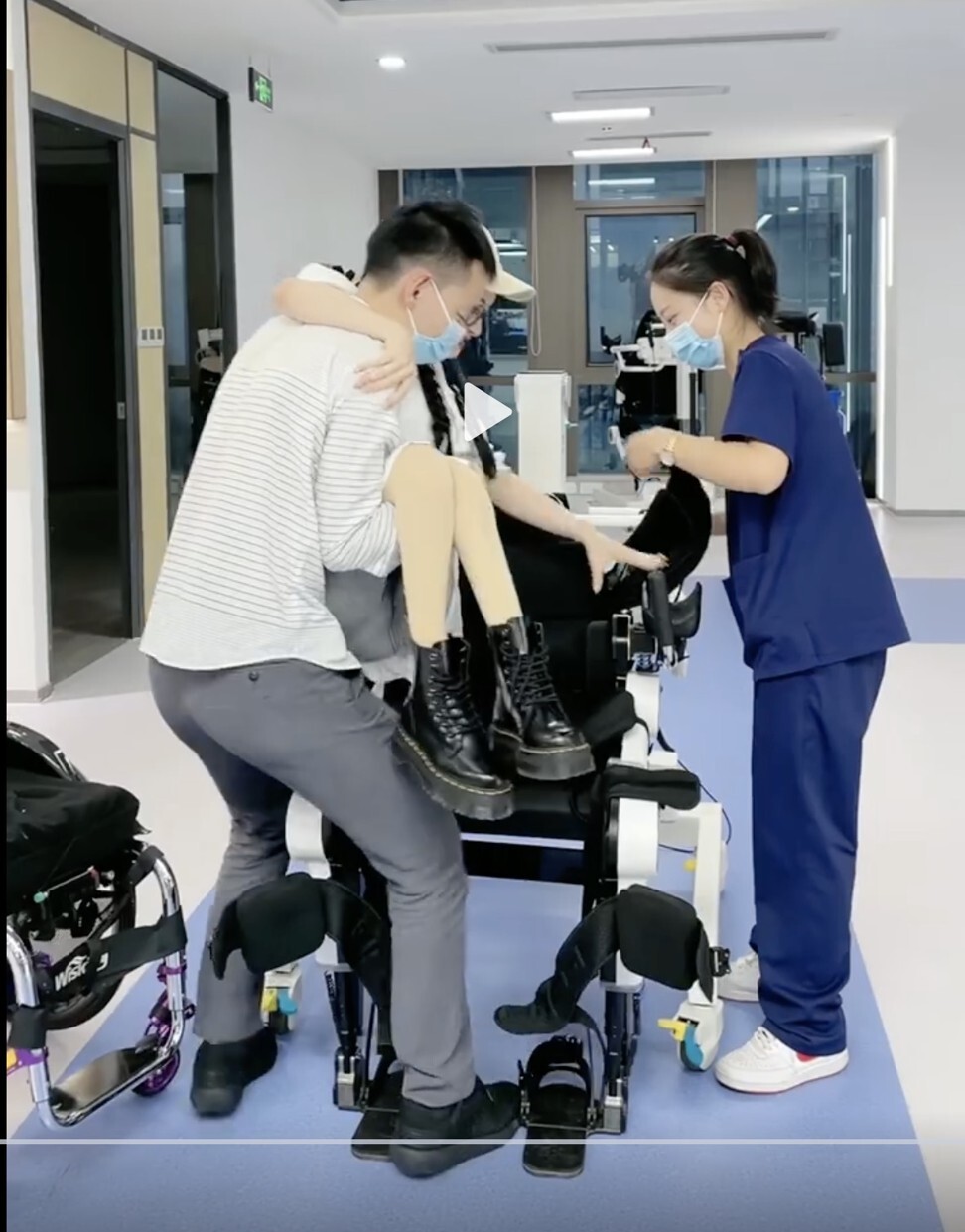 Medical workers help Duoduo get into the RoboCT exoskeleton equipment. Photo: Weibo