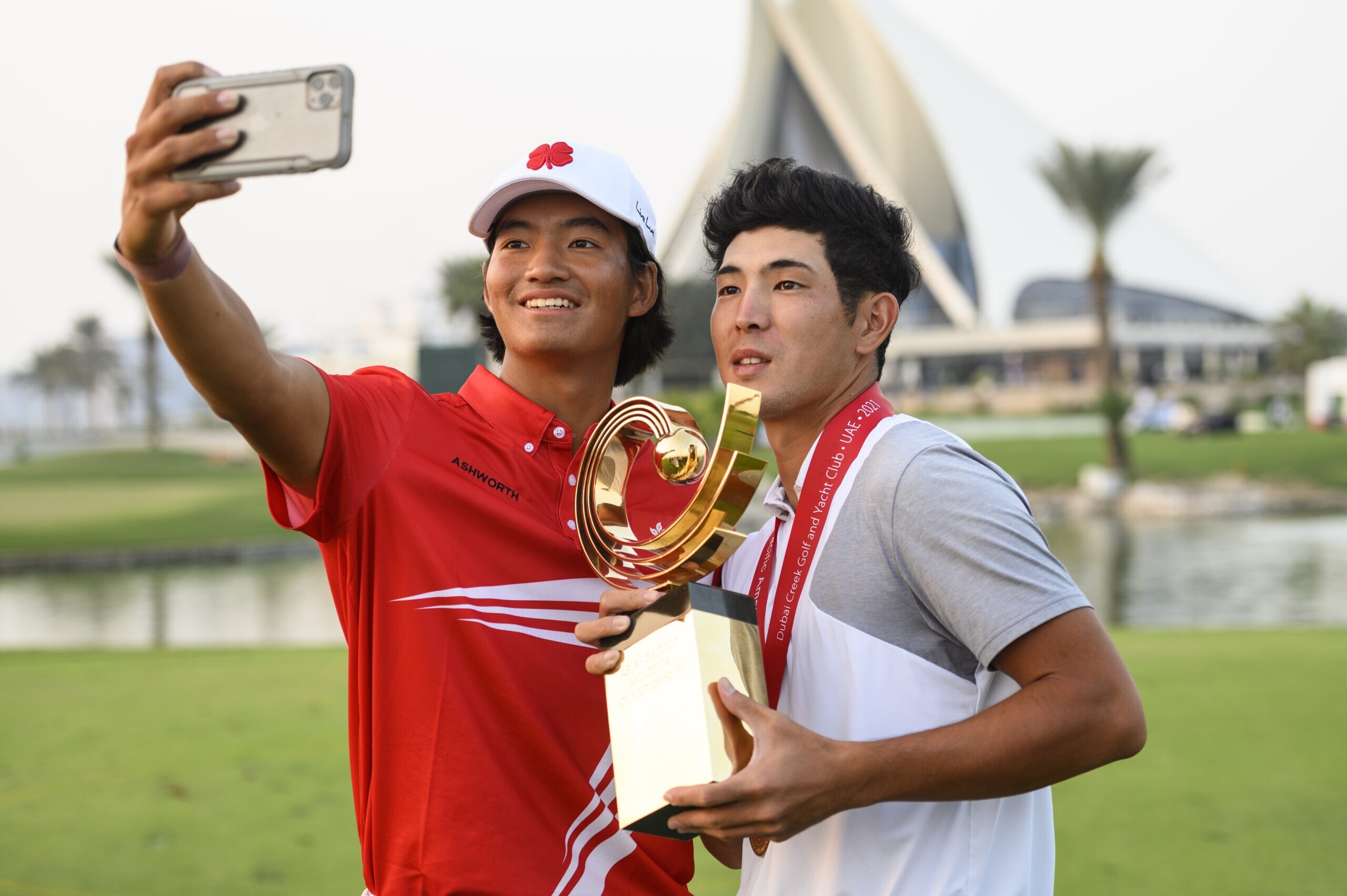 Runner up Taichi Kho of Hong Kong takes a selfie with winner Keita Nakajima of Japan and the AAC trophy after the 2021 Asia-Pacific Amateur Championship at the Dubai Creek Golf and Yacht Club. Photograph: AAC