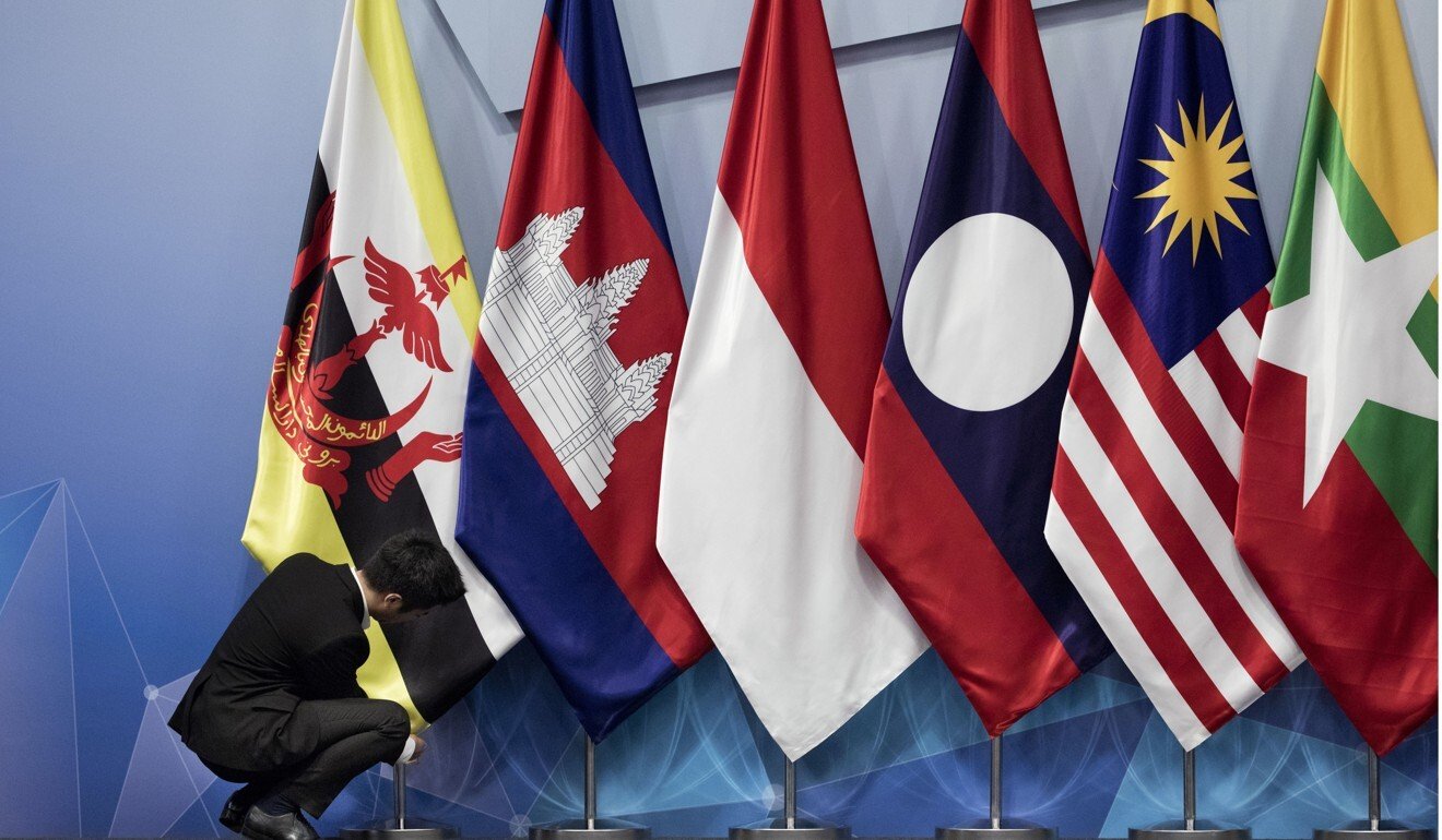 A worker adjusts the Brunei Darussalam flag prior to an Asean summit. Photo: AP