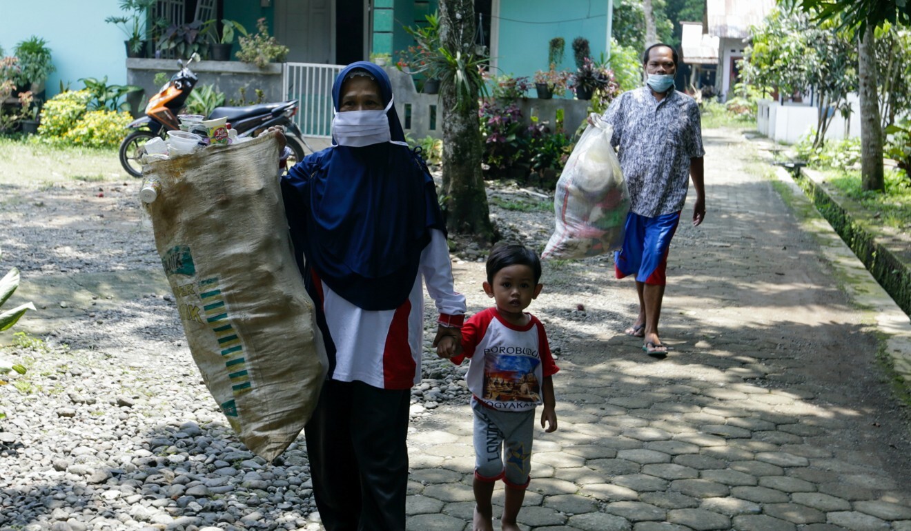 Residents of Muntang village carry waste to exchange for books at Raden’s eco-library. Photo: Reuters