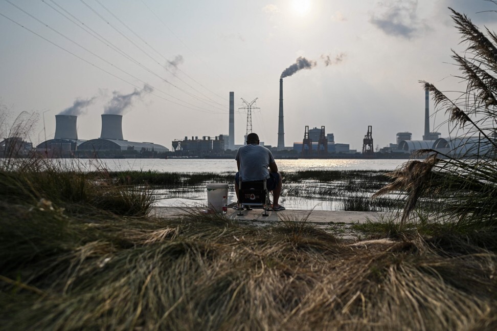 An angler is seen fishing along the Huangpu River across the Wujing Coal-Electricity Power Station in Shanghai on September 28, 2021. Photo: AFP