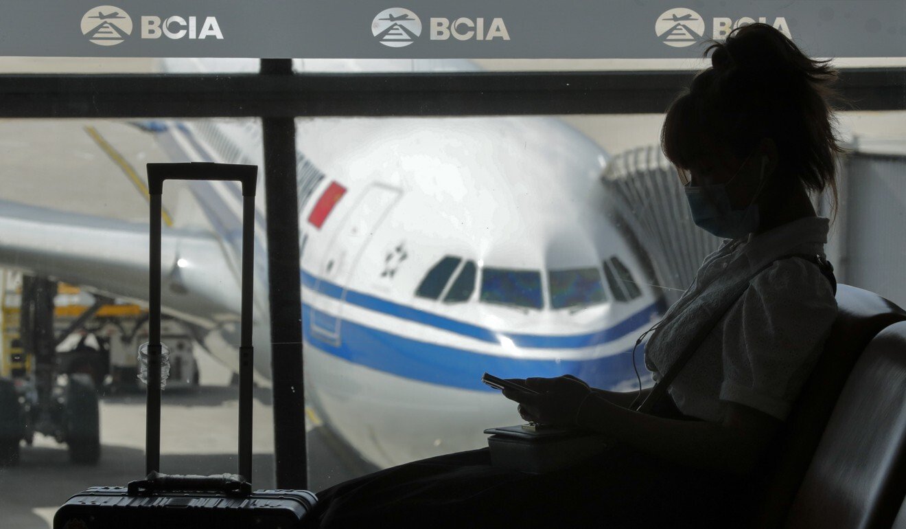 A woman browses her smartphone at the Beijing Capital International Airport. Chinese authorities are expressing concerns over the use of flight-tracking devices, according to a CCTV report. Photo: AP Photo