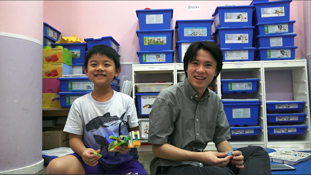 Playing with Lego all day? Joshua helps  a student during a lesson at Tadpoles.