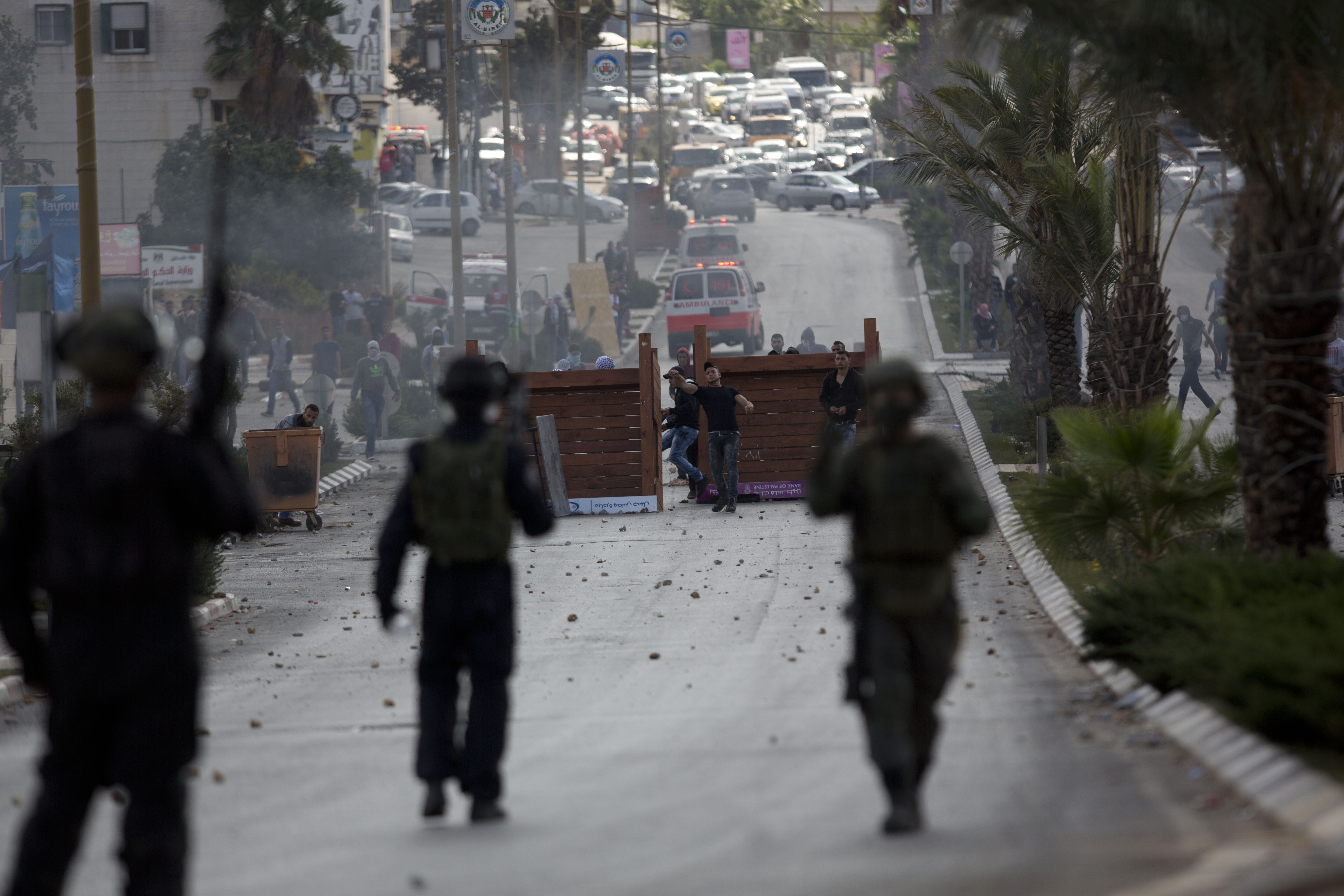 Palestinian protesters throw stones at Israeli security forces during clashes near Ramallah, West Bank, Thursday, Oct. 8, 2015. Dozens of Palestinian protesters threw stones at Israeli troops near the West Bank city of Ramallah and elsewhere on Thursday. Israeli forces responded with tear gas and stun grenades. (AP Photo/Majdi Mohammed)