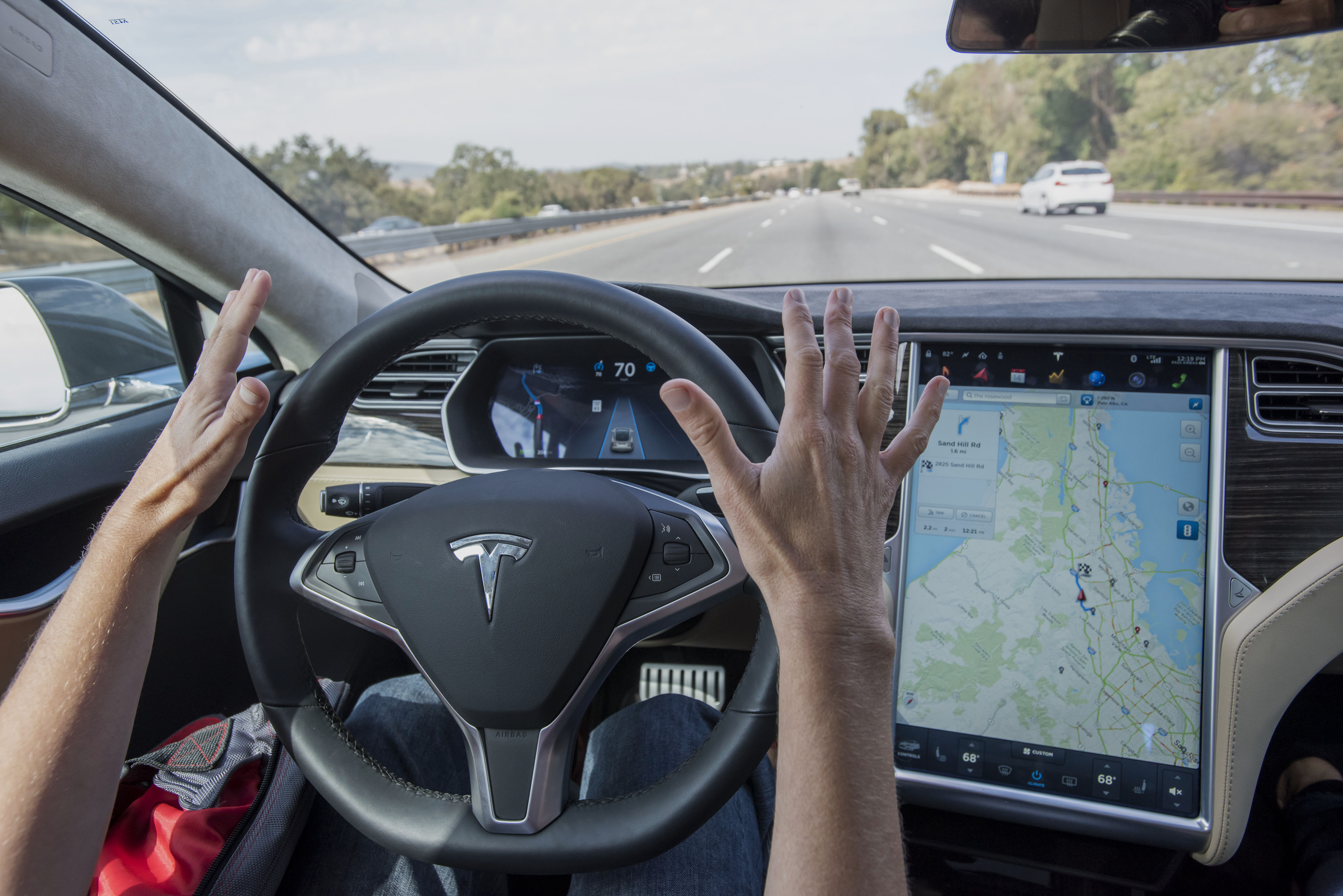 A member of the media test drives a Tesla Motors Inc. Model S car equipped with Autopilot in Palo Alto, California, U.S., on Wednesday, Oct. 14, 2015. Tesla Motors Inc. will begin rolling out the first version of its highly anticipated "autopilot" features to owners of its all-electric Model S sedan Thursday. Autopilot is a step toward the vision of autonomous or self-driving cars, and includes features like automatic lane changing and the ability of the Model S to parallel park for you. Photographer: David Paul Morris/Bloomberg