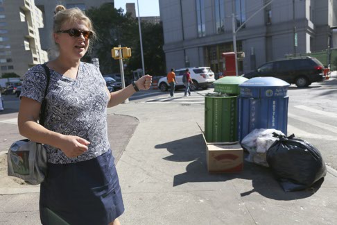 In this Thursday, Sept. 17, 2015, photo, Caroline Bragdon, a rat expert with New York City's Department of Health and Mental Hygiene, points out garbage containers near a park in the Chinatown neighborhood of New York. The city's complaint hotline is on pace for a record year of rat calls, exceeding the more than 24,000 over each of the last two years. (AP Photo/Mary Altaffer)