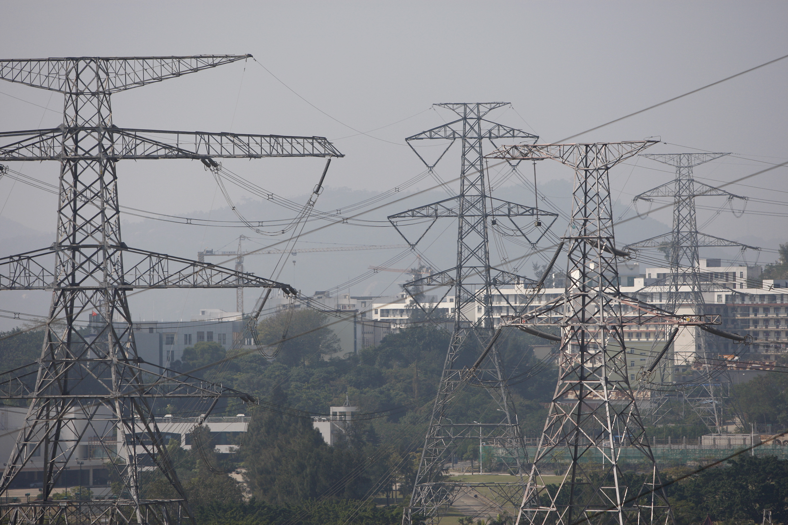 Power lines hang from electricity pylons in Daya Bay, near Shenzhen, China, on Tuesday, Dec. 22, 2009. The Daya Bay Nuclear Power Plant, which supplies 70% of CLP Holdings Ltd.'s electric supply, was the first commercial nuclear power plant on China's mainland. Photographer: Scott Eells/Bloomberg