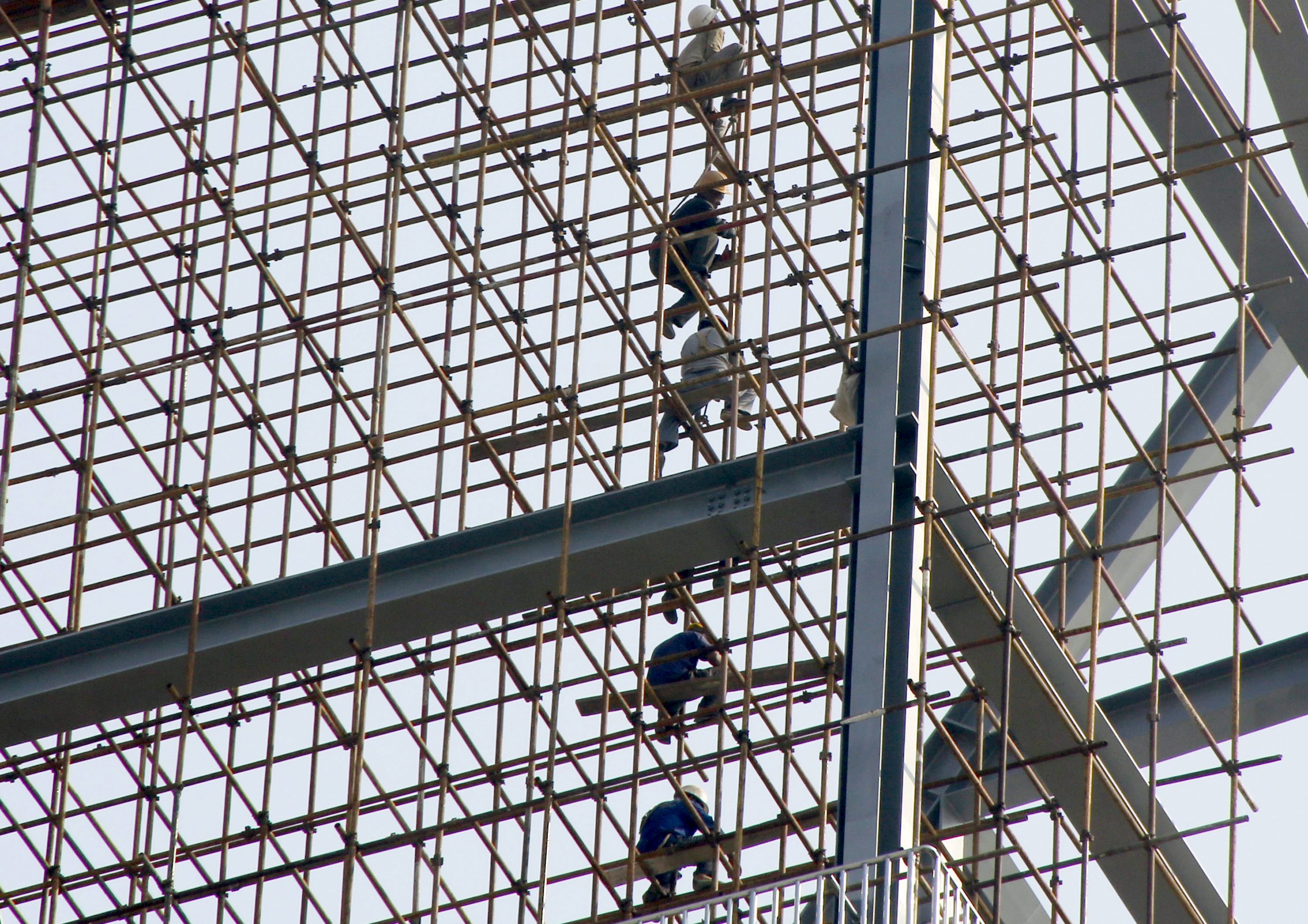 Labourers work on scaffolding of a construction site of a residential and commercial complex in Beijing, China, September 18, 2015. Home prices in China rose for a fourth consecutive month in August, offering hope that the ailing property sector is becoming less of a drag on the slowing economy. REUTERS/Kim Kyung-Hoon