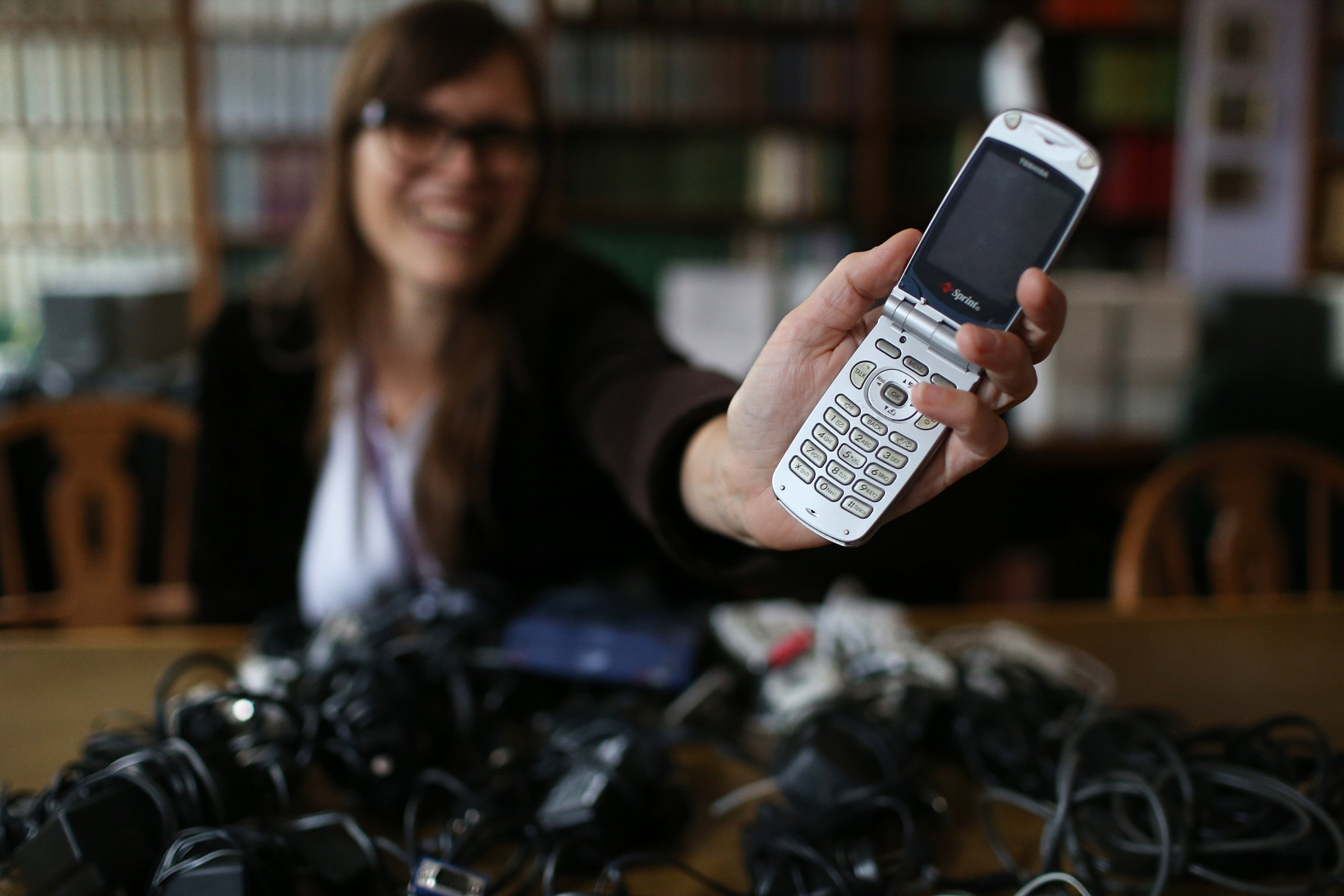 At Northwestern University in Evanston, Ill., Digital Curation Librarian Nicole Finzer holds in her hand Friday, Oct. 24, 2015 a Toshiba PCS Vision Video Phone, a flip-phone model from the early 2000's that belonged to the late actress Karen Black, a university alumna. A search for a connecting cord for the phone led to the #UndeadTech campaign, an effort to collect old power and data cords to pull information off outdated technology. (Chris Walker/Chicago Tribune/TNS)
