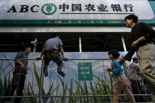 People walk past a branch of Agricultural Bank of China in Shanghai, in this May 14, 2013 file photo. China's AgBank ins expected to release Q3 results this week. REUTERS/Aly Song/Files GLOBAL BUSINESS WEEK AHEAD PACKAGE - SEARCH "BUSINESS WEEK AHEAD OCTOBER 19" FOR ALL 37 IMAGES