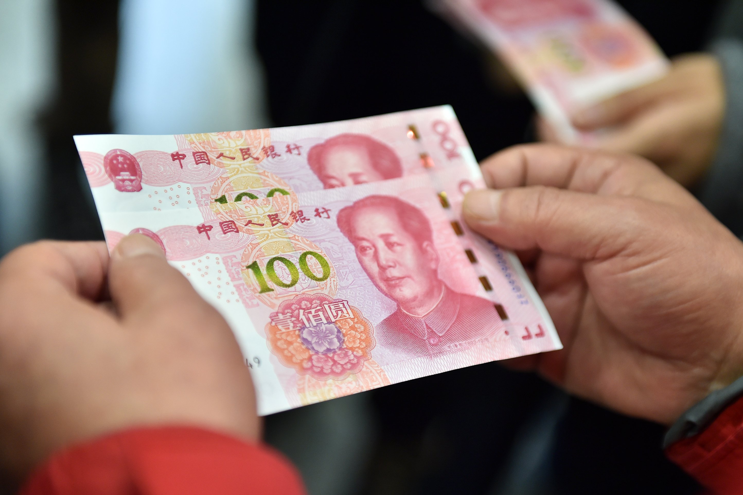 (151112) -- BEIJING, Nov. 12, 2015 (Xinhua) -- Residents hold two new 100-yuan banknotes withdrawn from the Beijing Branch of the Bank of Communication in Beijing, capital of China. China's central bank released a new 100-yuan banknote on Thursday. The design stays largely the same as its former series, but the new banknotes are harder to conterfeit and easier for machines to read. The 100-yuan note is the largest denomination of the Chinese currency. (Xinhua/Li Xin) (lfj)