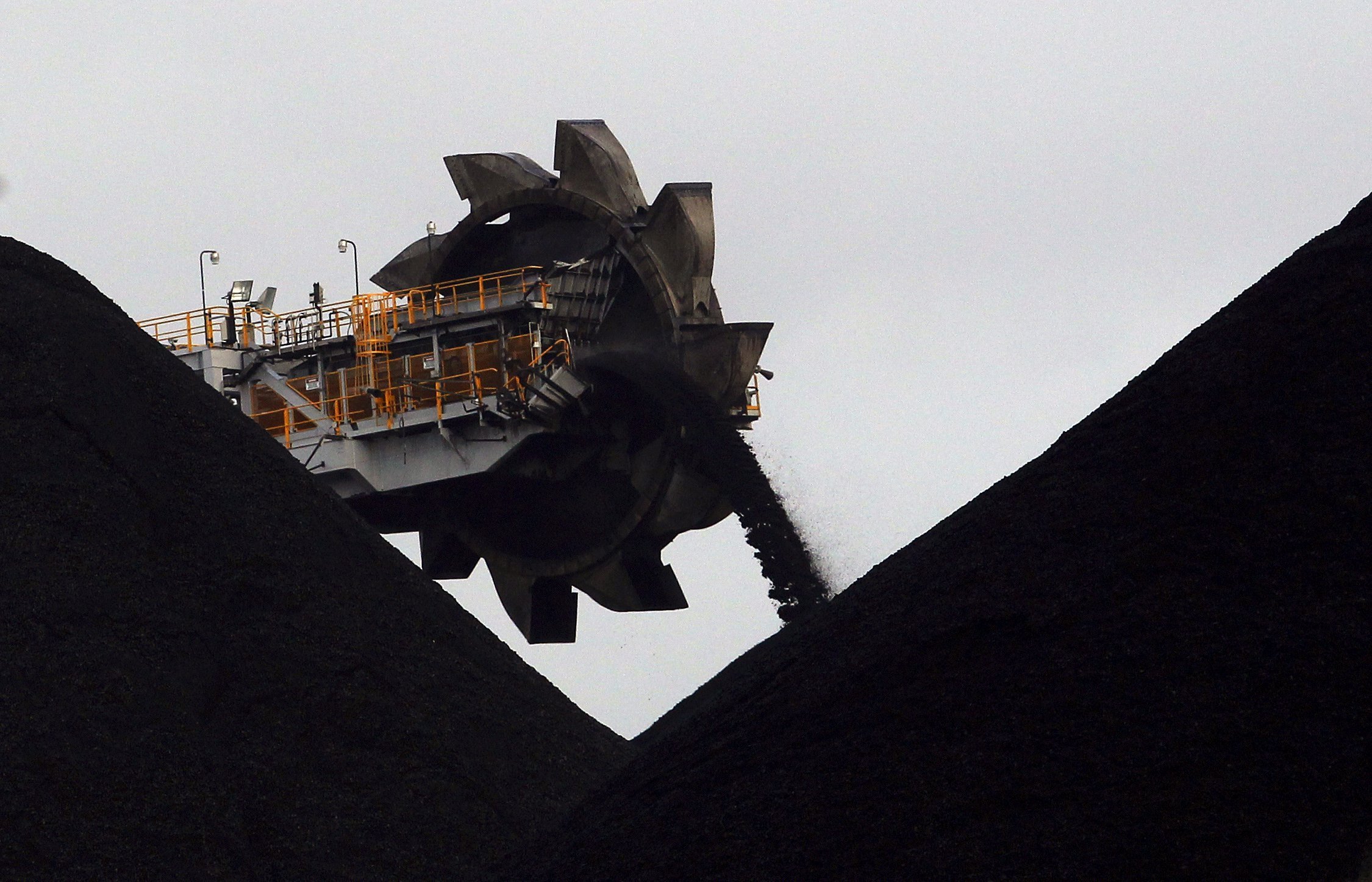A reclaimer places coal in stockpiles at the coal port in Newcastle in this June 6, 2012 file photo. As debate swirls around the future of coal, Australian miners are counting on the higher energy content of the coal they dig and proximity to growing Asian markets to give them an edge over rivals and defy a global push towards cleaner energy. With around $35 billion in projects in the pipeline, the world's No.2 exporter of thermal coal is relying on Asian markets using the cheapest source of power even as they try to contain soaring emissions and choking pollution. To match AUSTRALIA-COAL/ REUTERS/Daniel Munoz/Files