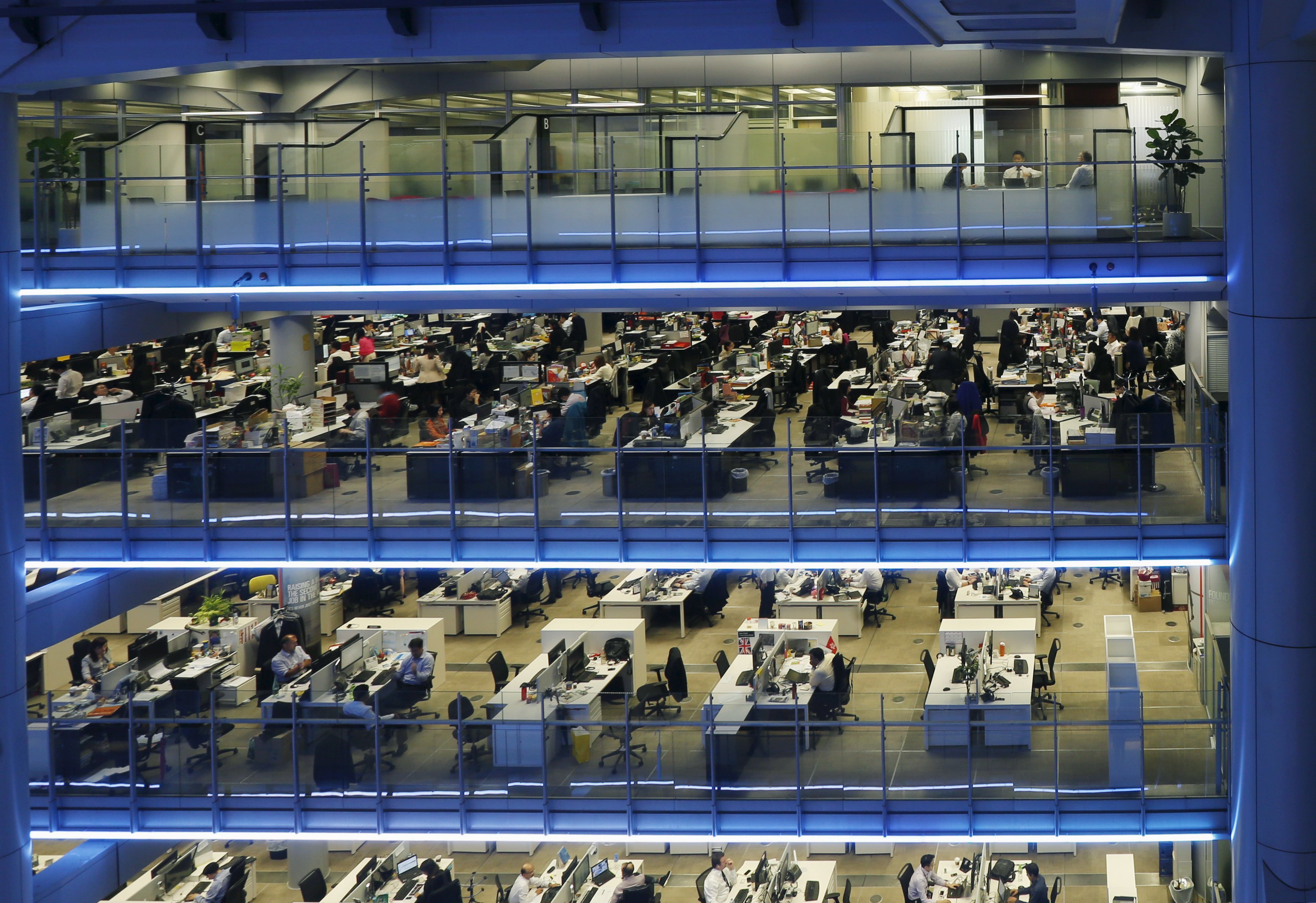 Staff work inside the HSBC headquarters in Hong Kong November 3, 2015. HSBC is seeking to overtake Western rivals in the race for a slice of China's $4 trillion onshore bond market thanks to an investment banking partnership with a state-owned investor it announced last week. Picture taken November 3, 2015. REUTERS/Bobby Yip