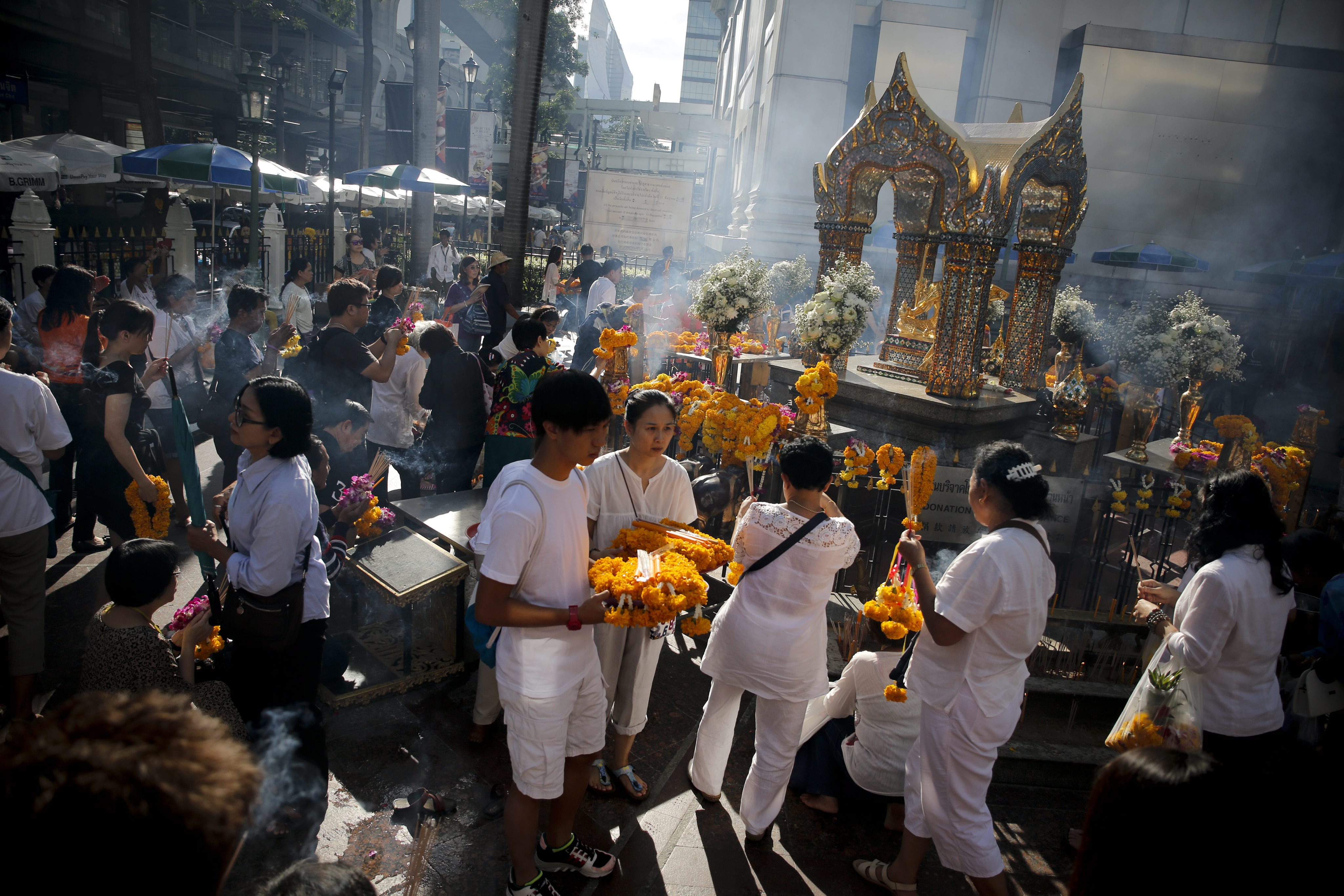 epa04912019 People pray at the Erawan Shrine after Brahmin priests performed a religious ceremony to worship the Lord Brahma statue after it was renovated following the deadly bombing of 17 August, in Bangkok, Thailand, 04 September 2015. The casualty figures from the deadly attack outside the Erawan Shrine on 17 August stood at 20 dead and 123 injured according to the Erawan Medical Centre. EPA/DIEGO AZUBEL