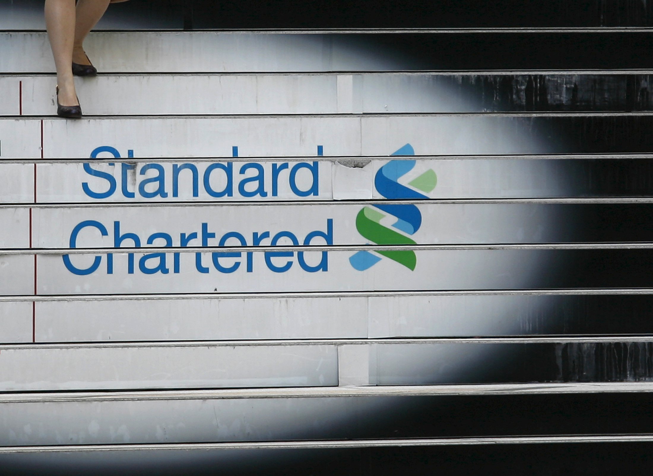 A woman walks down the stairs of the Standard Chartered headquarters in Hong Kong in this October 13, 2010 file photo. Standard Chartered is expected to report Q3 results this week. REUTERS/Bobby Yip/Files GLOBAL BUSINESS WEEK AHEAD PACKAGESEARCH "BUSINESS WEEK AHEAD NOV 2" FOR ALL 82 IMAGES