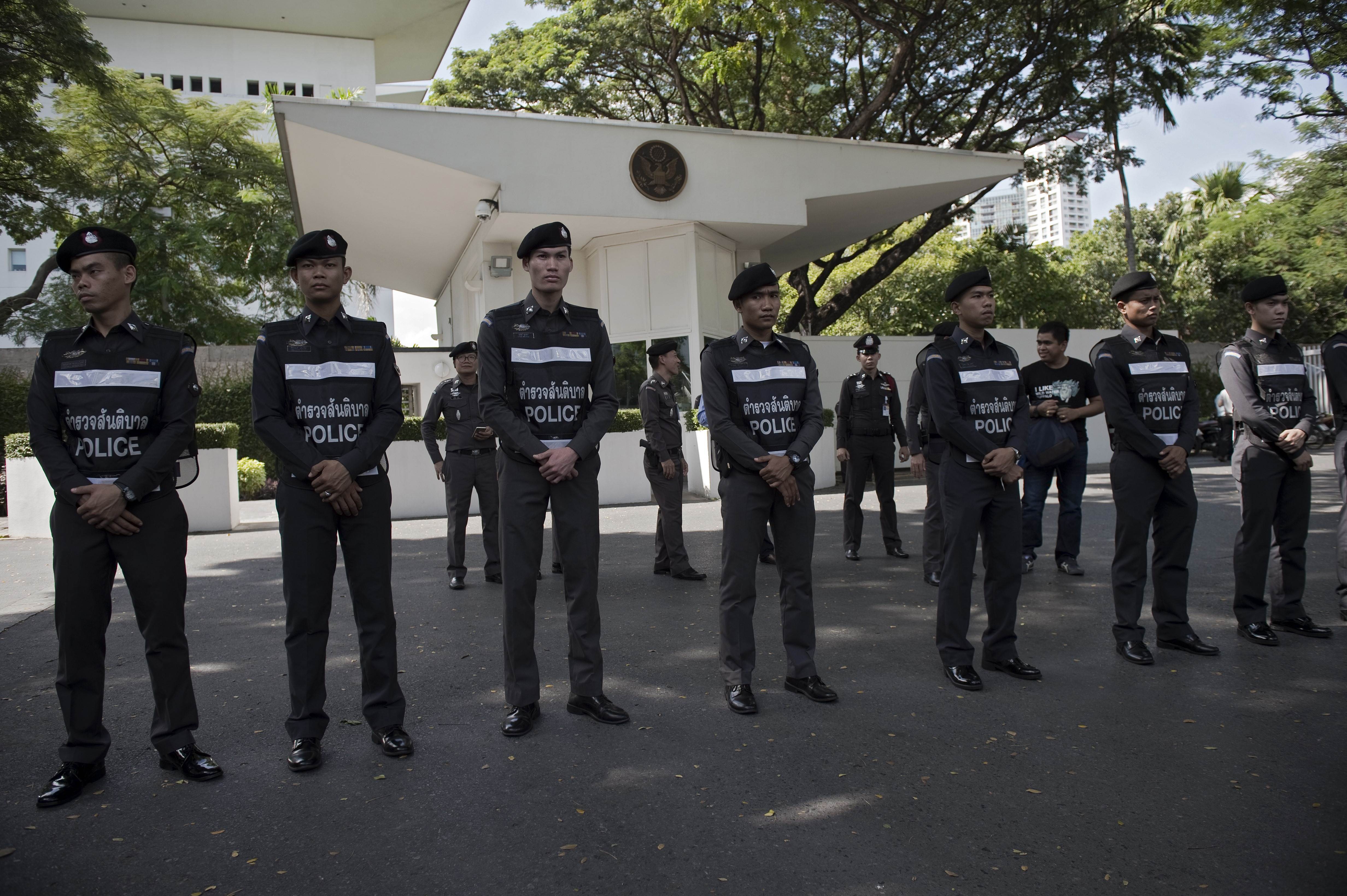 Police officers secure the front entrance of the US embassy as supporters of Thai nationalist monk Buddha Issara (not seen) hold a protest in Bangkok on November 27, 2015. An arch-royalist Thai monk led a protest against the United States envoy to Thailand after he criticised the jailing of civilians under the kingdom's tough royal defamation law. AFP PHOTO / Nicolas ASFOURI
