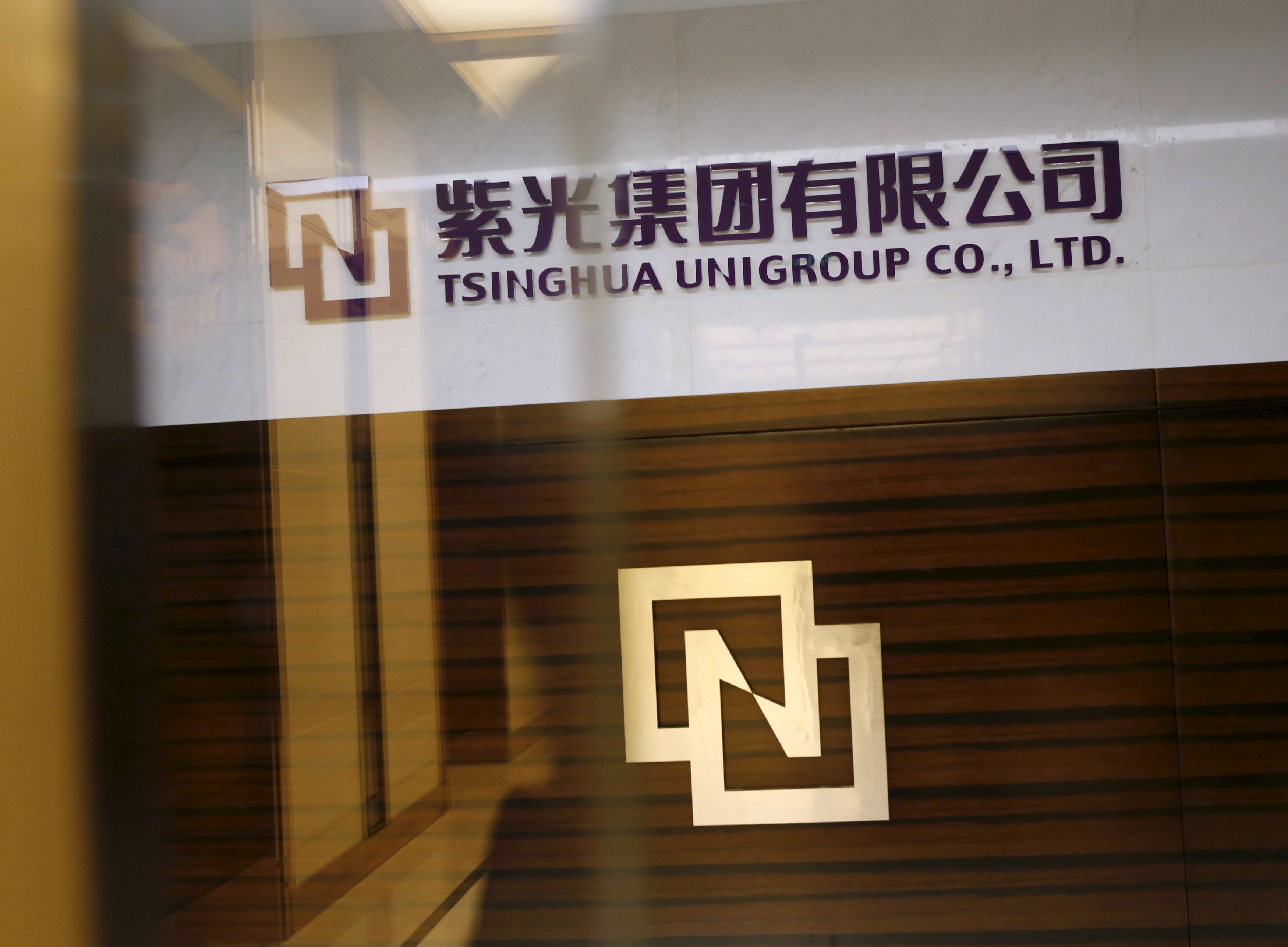 Tsinghua Unigroup logo is seen at its office in Beijing, China, November 15, 2015. China's Tsinghua Unigroup Ltd plans to invest 300 billion yuan ($47 billion) over the next five years to build the world's third-biggest chipmaker, the chairman of the state-backed technology conglomerate said on Monday. Chairman Zhao Weiguo told Reuters in an interview that Tsinghua Unigroup, controlled by Beijing's elite Tsinghua University which counts President Xi Jinping among its alumni, was in talks with a U.S.-based company involved in the chip industry. Picture taken November 15, 2015. REUTERS/Kim Kyung-Hoon