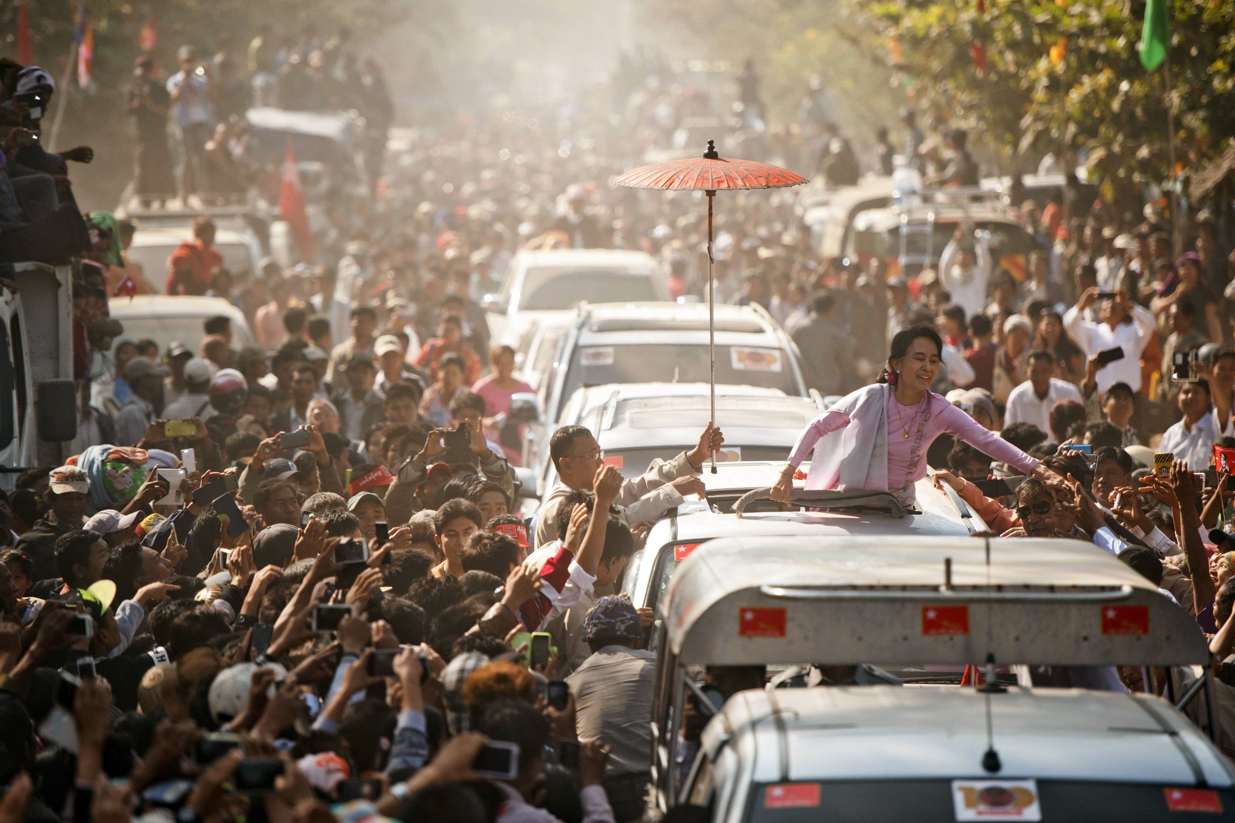 -- AFP PICTURES OF THE YEAR 2015 -- Myanmar opposition leader Aung San Suu Kyi greets supporters as she leaves a ceremony to mark the 100th birthday of independence hero Aung San, in the remote central Myanmar town of Natmauk on February 13, 2015. Known affectionately as "Bogyoke", or General, Aung San is adored in Myanmar and credited with unshackling the country from colonial rule and embracing its ethnic minorities in a vision of unity that unraveled catastrophically in the military-dominated decades that followed his 1947 assassination. AFP PHOTO / YE AUNG THU