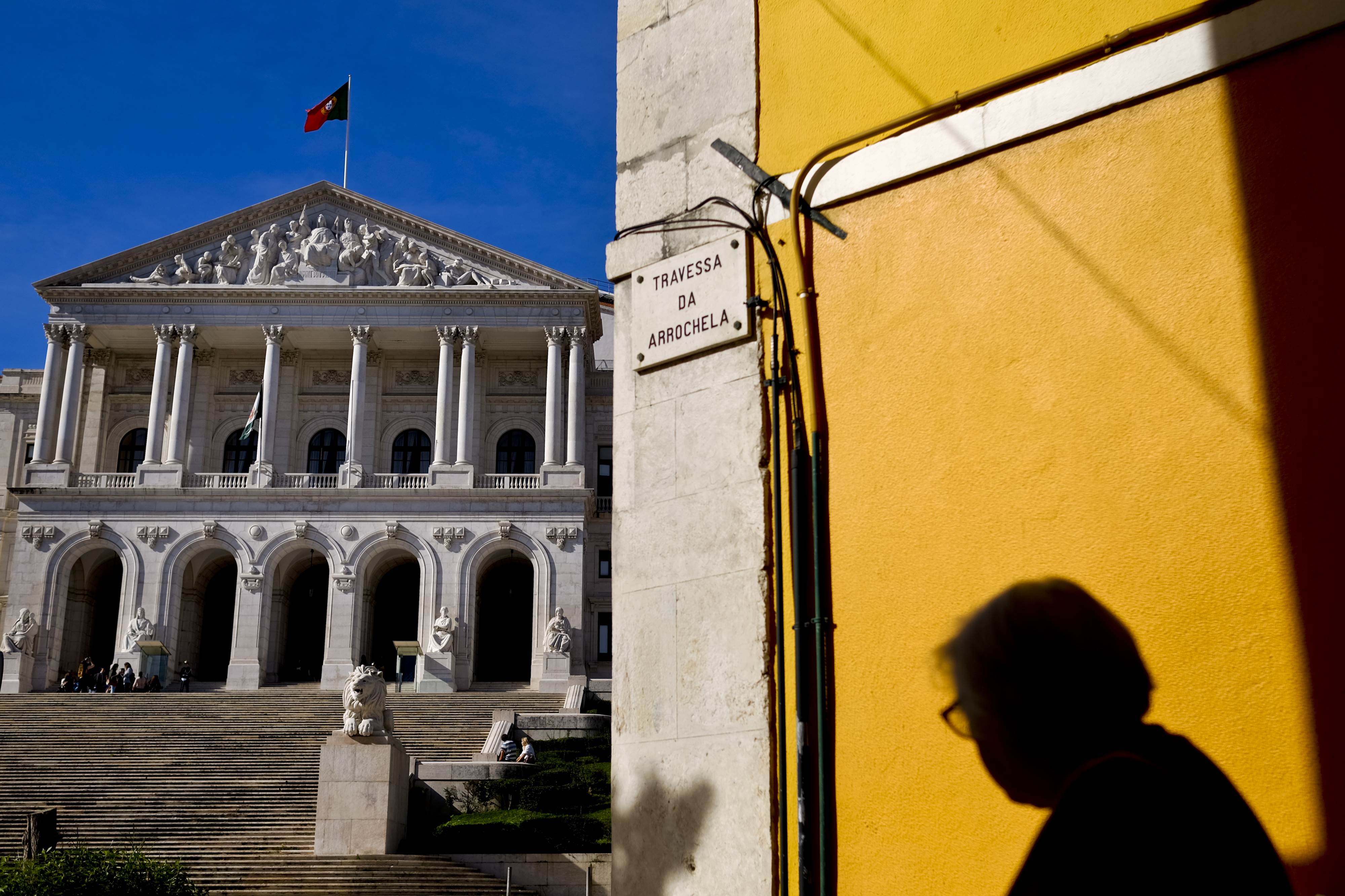 A woman passes infront of the Portuguese parliament in Lisbon on November 11, 2015 a day after the fall of the 11-day-old conservative minority government. President Anibal Cavaco Silva is set to decide whether to charge Socialist leader Antonio Costa with forming a new government in the face of concerns over whether the fragile leftist alliance can last. AFP PHOTO / PATRICIA DE MELO MOREIRA