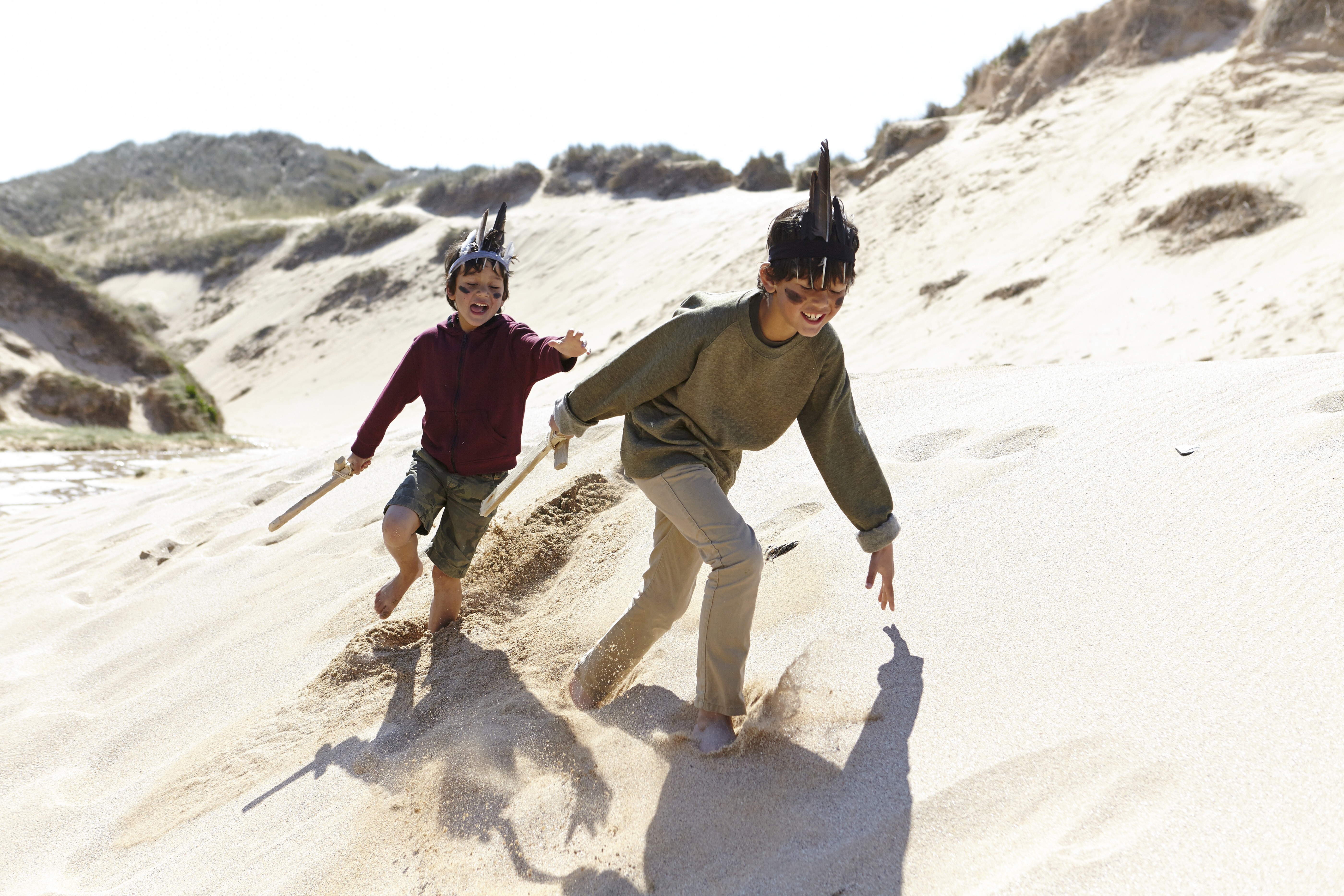 19 Apr 2015 --- Two boys, wearing fancy dress, playing on sand --- Image by © Janie Airey/Corbis [15DECEMBER2015 FEATURES FAMILY]