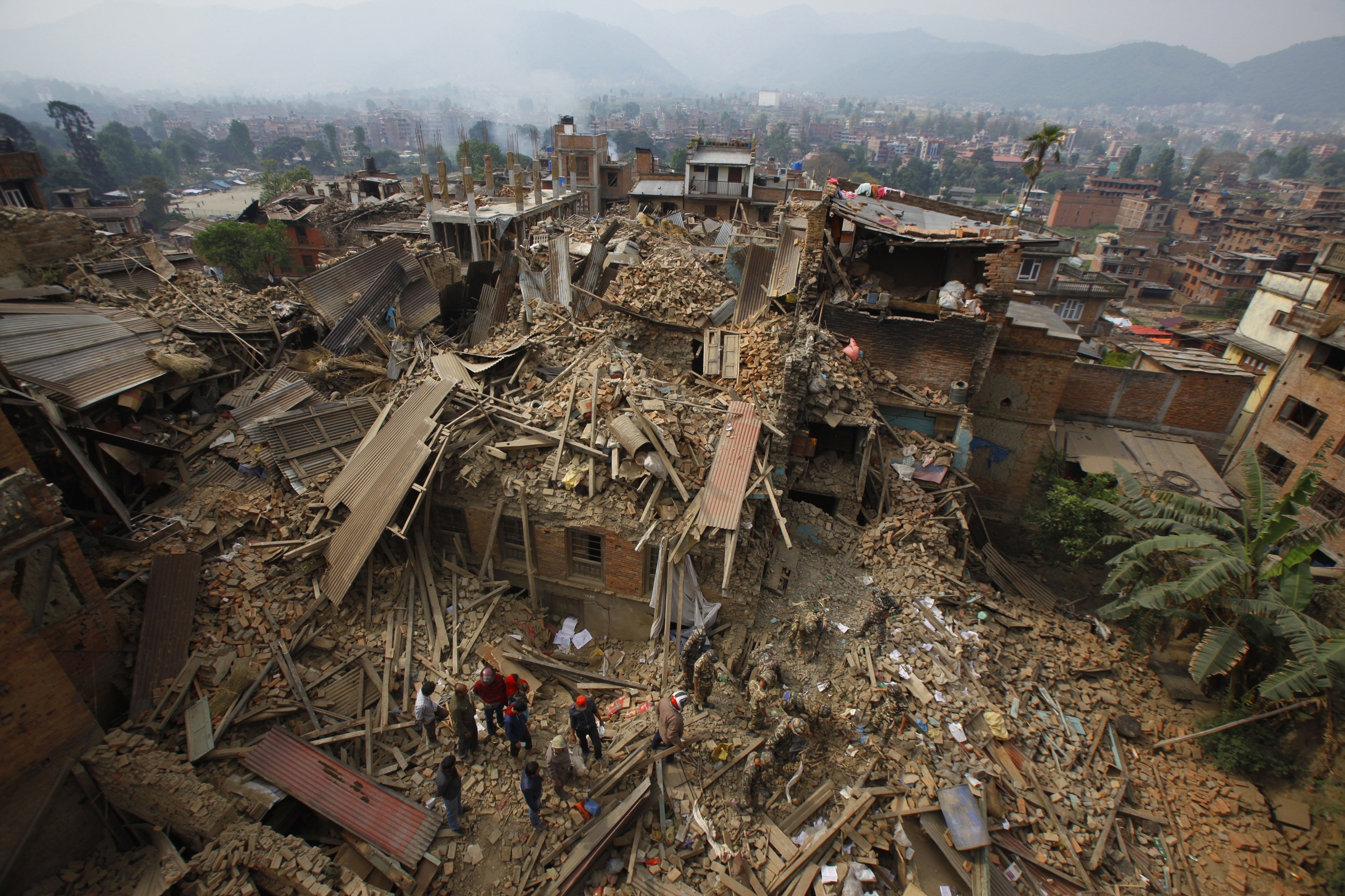 In this April 26, 2015, file photo, rescue workers remove debris as they search for victims of an earthquake in Bhaktapur near Kathmandu, Nepal. A strong magnitude earthquake shook Nepal's capital and the densely populated Kathmandu Valley before noon Saturday, causing extensive damage with toppled walls and collapsed buildings, officials said. (AP Photo/Niranjan Shrestha, File)