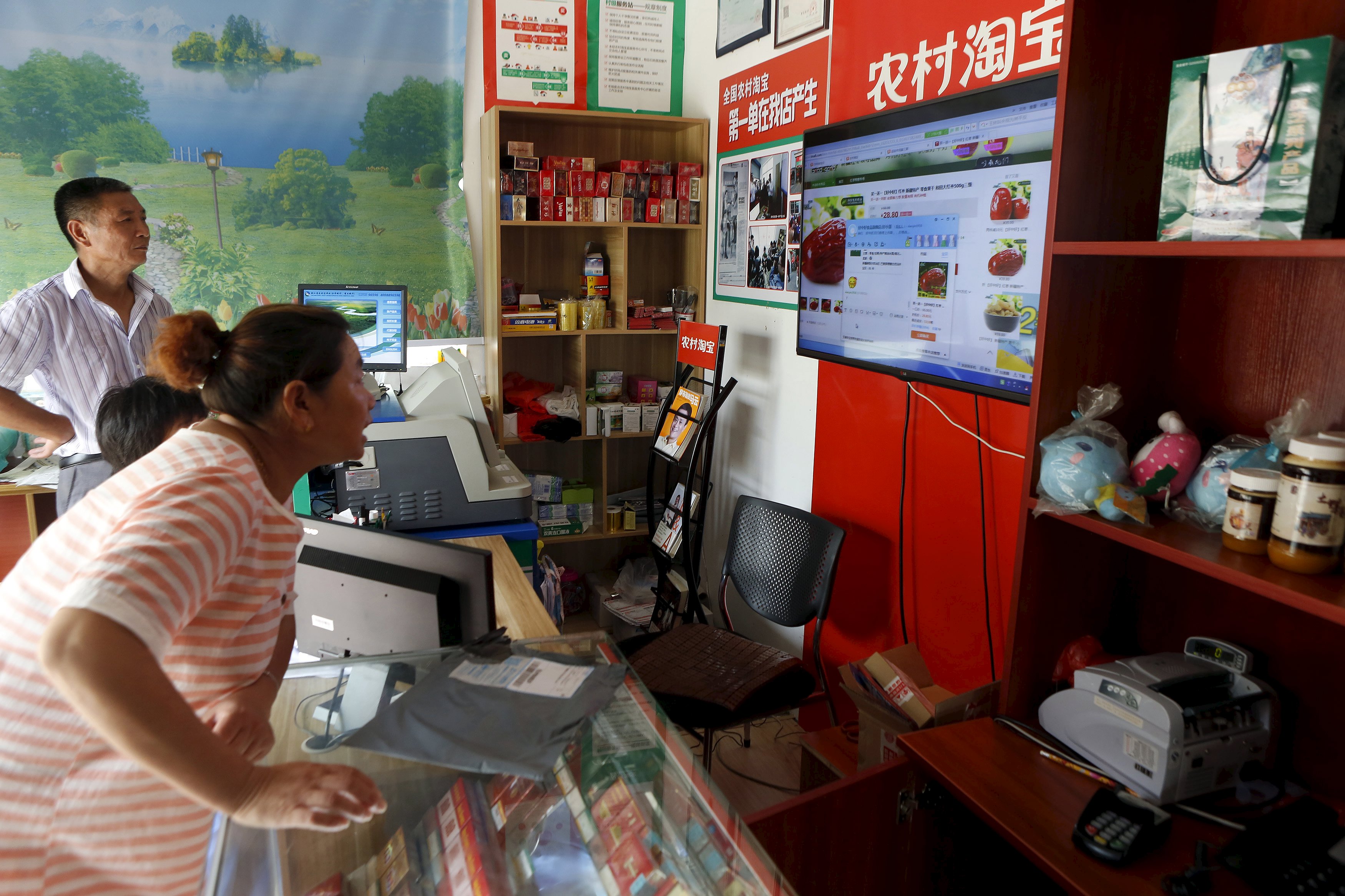 A customer shops at an Alibaba rural service centre in Jinjia Village, Tonglu, Zhejiang province, China, July 20, 2015. E-commerce growth in the countryside now outpaces that in major cities, though fewer than one tenth of online purchases made on Alibaba platforms were shipped to rural areas in the first quarter of this year. Alibaba estimates the potential market at 460 billion yuan ($74 billion) by next year. Picture taken July 20. REUTERS/Aly Song