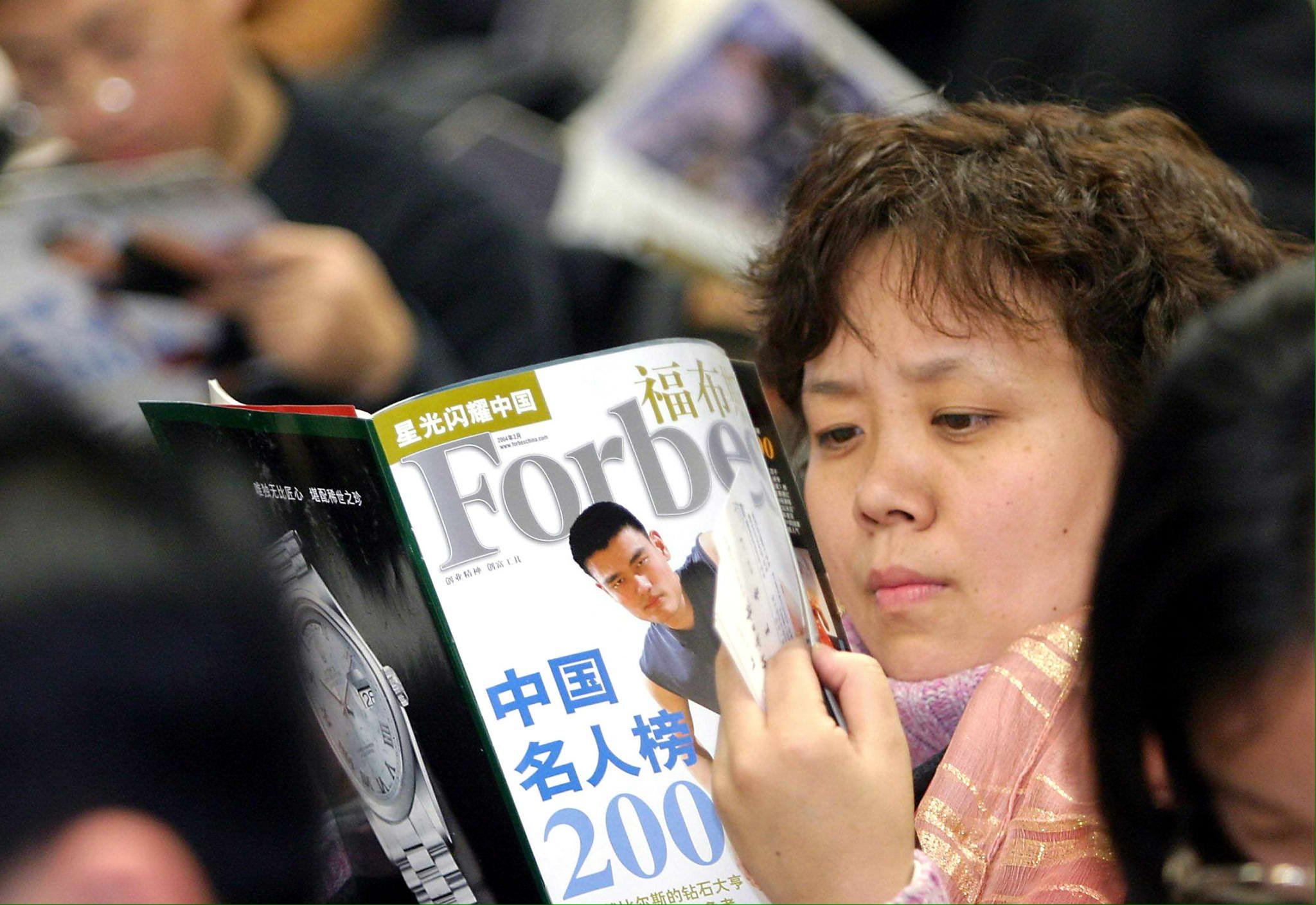 Chinese guests read copies of the magazine with the list of China's most popular people, with the cover of basketball star Yao Ming, during a press conference in Beijing 10 February 2004. The rise of high-tech tycoons is the most significant feature of the 2003 Forbes China Rich List with William Ding, founder and chief architect of the Chinese Internet company Netease.com Inc, topped the list with wealth of US$1.06 billion based on his holdings' market capitalization on October 13. Ding, who owns 58.5 per cent in NASDAQ-listed Netease, has seen his stocks rise 20 times last year and almost fivefold this year., and while out of the 100 richest people, 16 are from Guangdong Province, 13 from Shanghai, 10 from East China's Zhejiang Province, and nine from Beijing. AFP PHOTO