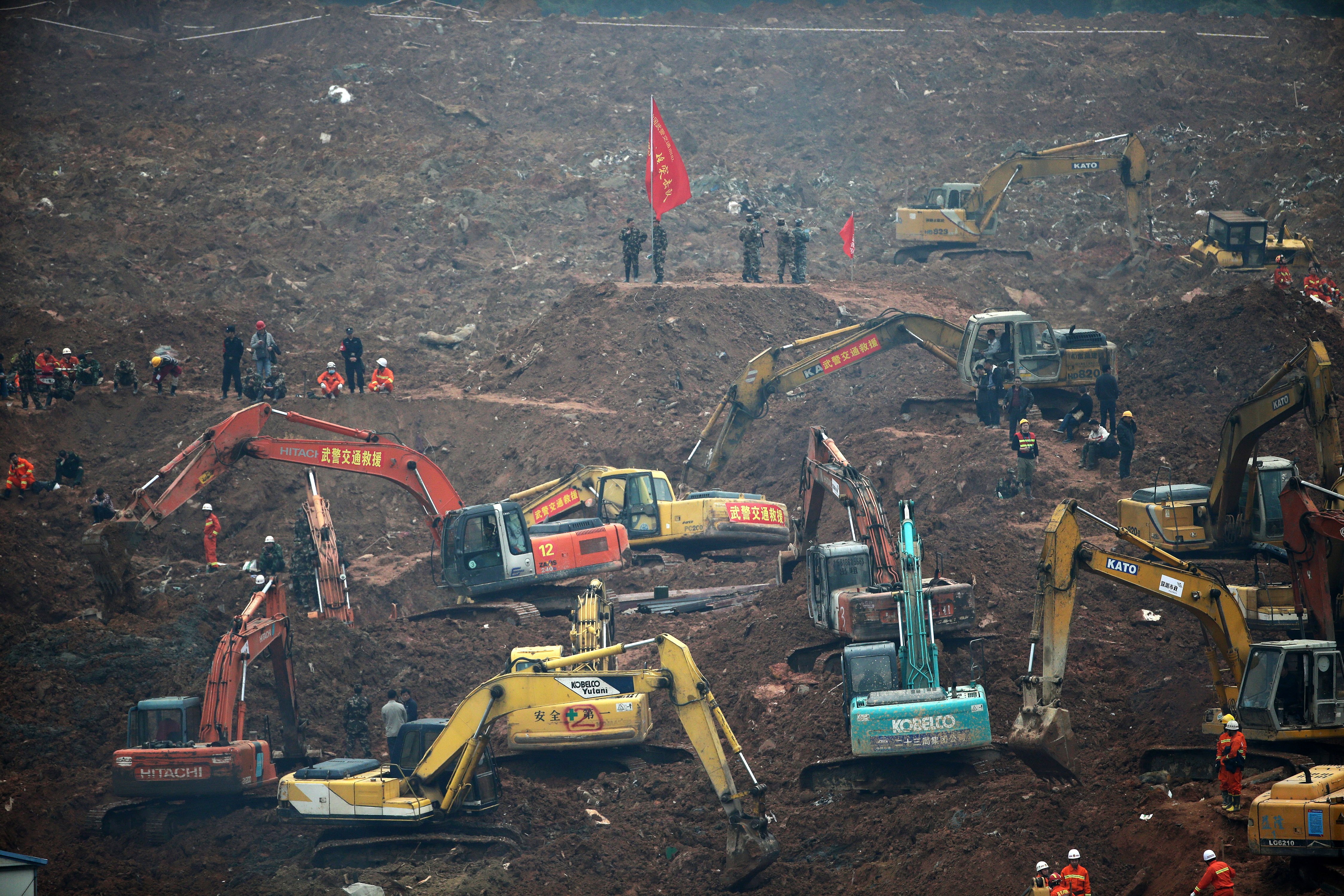 Rescuers using machinery to search for potential survivors, following a landslide in Shenzhen, in south China's Guangdong province, Monday, Dec. 21, 2015. A mountain of excavated soil and construction waste buried dozens of buildings when it swept through an industrial park Sunday. (AP Photo/Andy Wong)
