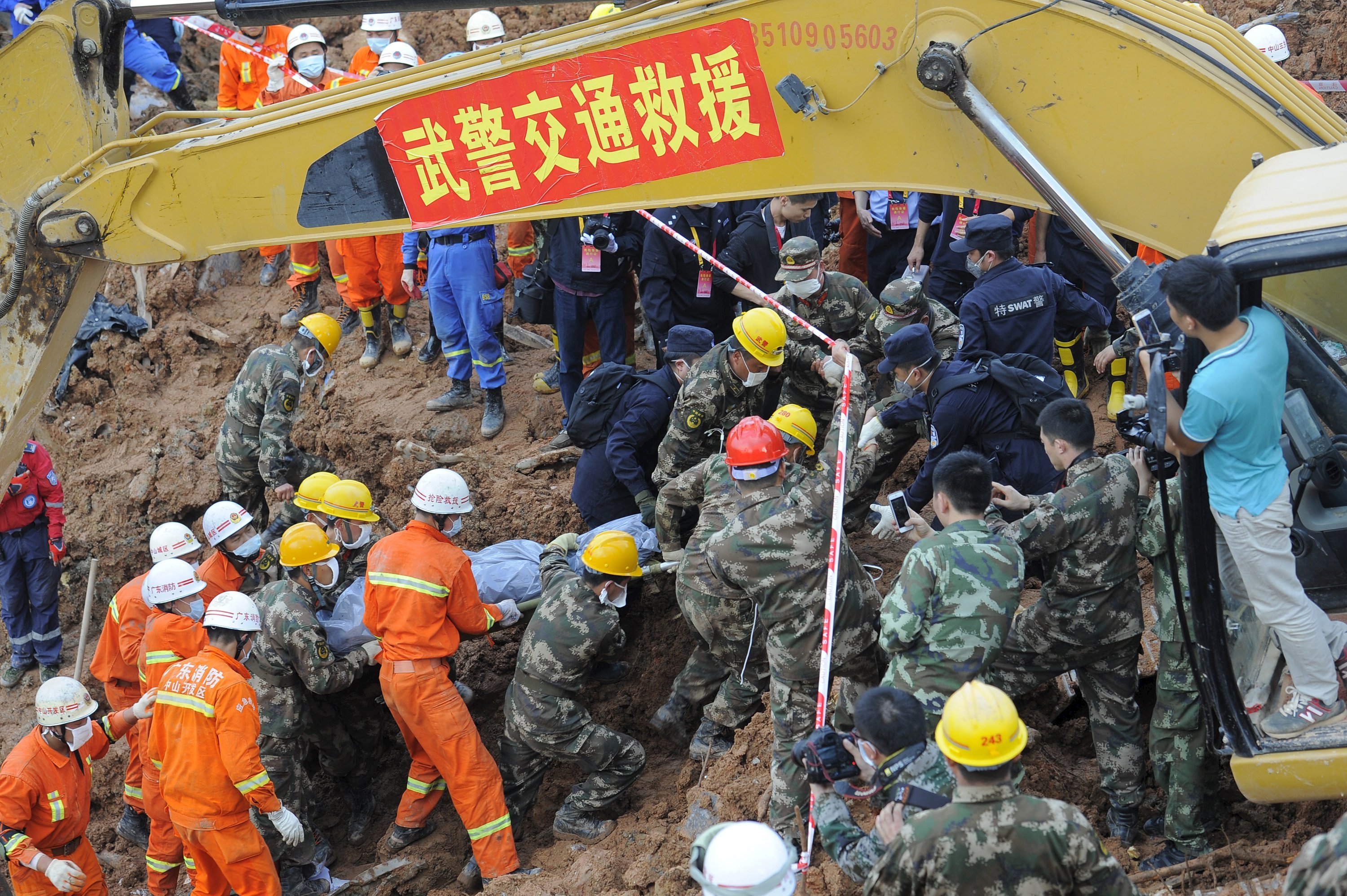 Rescuers carry the body of a victim after being pulled out among the debris of at the site of a landslide which hit an industrial park on Sunday, in Shenzhen, Guangdong province, China, December 23, 2015. Picture taken December 23, 2015. REUTERS/Stringer ATTENTION EDITORS - THIS PICTURE WAS PROVIDED BY A THIRD PARTY. THIS PICTURE IS DISTRIBUTED EXACTLY AS RECEIVED BY REUTERS, AS A SERVICE TO CLIENTS. CHINA OUT. NO COMMERCIAL OR EDITORIAL SALES IN CHINA.