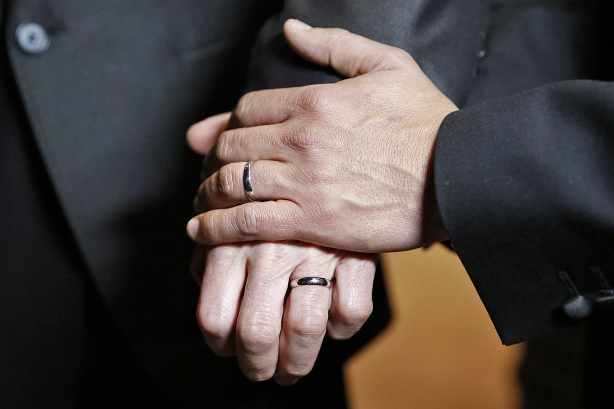 British couple Peter McGraith and David Cabreza show their wedding rings after their wedding at Islington Town Hall in London March 29, 2014. McGraith and Cabreza, who have been a couple for 17 years, married shortly after midnight on Friday, marking the culmination of a campaign to end a distinction many British gay couples say made them feel like second class citizens. REUTERS/Olivia Harris (BRITAIN - Tags: SOCIETY)