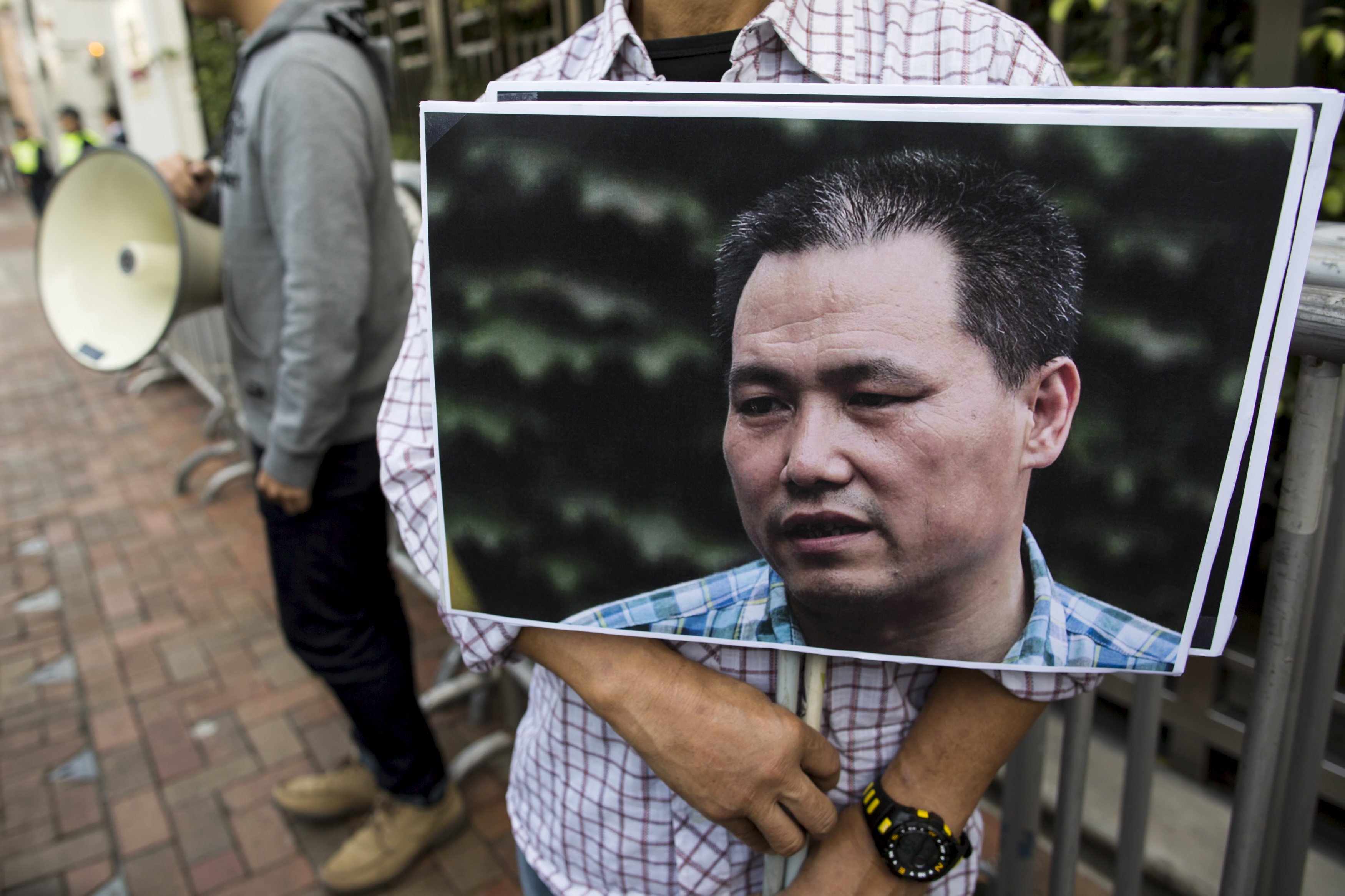 A pro-democracy protester holds a portrait of Chinese human rights lawyer Pu Zhiqiang, demanding his release during a demonstration, outside the Chinese liaison office in Hong Kong, China December 15, 2015. REUTERS/Tyrone Siu