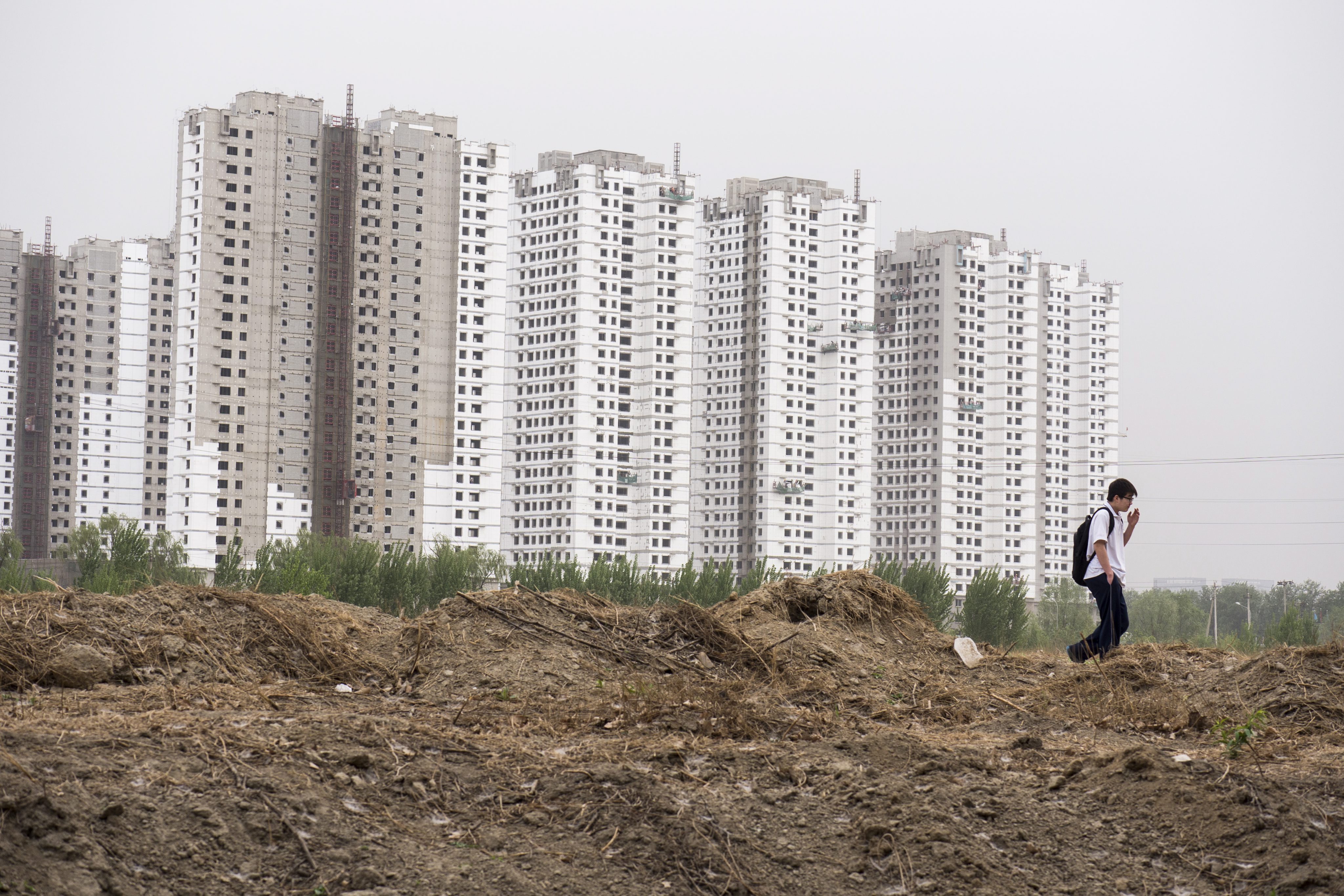 epa04167734 Highrise housing is under construction in the Maquanying district in the suburbs of Beijing, China, 15 April 2014. Housing data due to be published 18 April is anxiously awaited as a key indicator of China's slowing economy. EPA/ADRIAN BRADSHAW