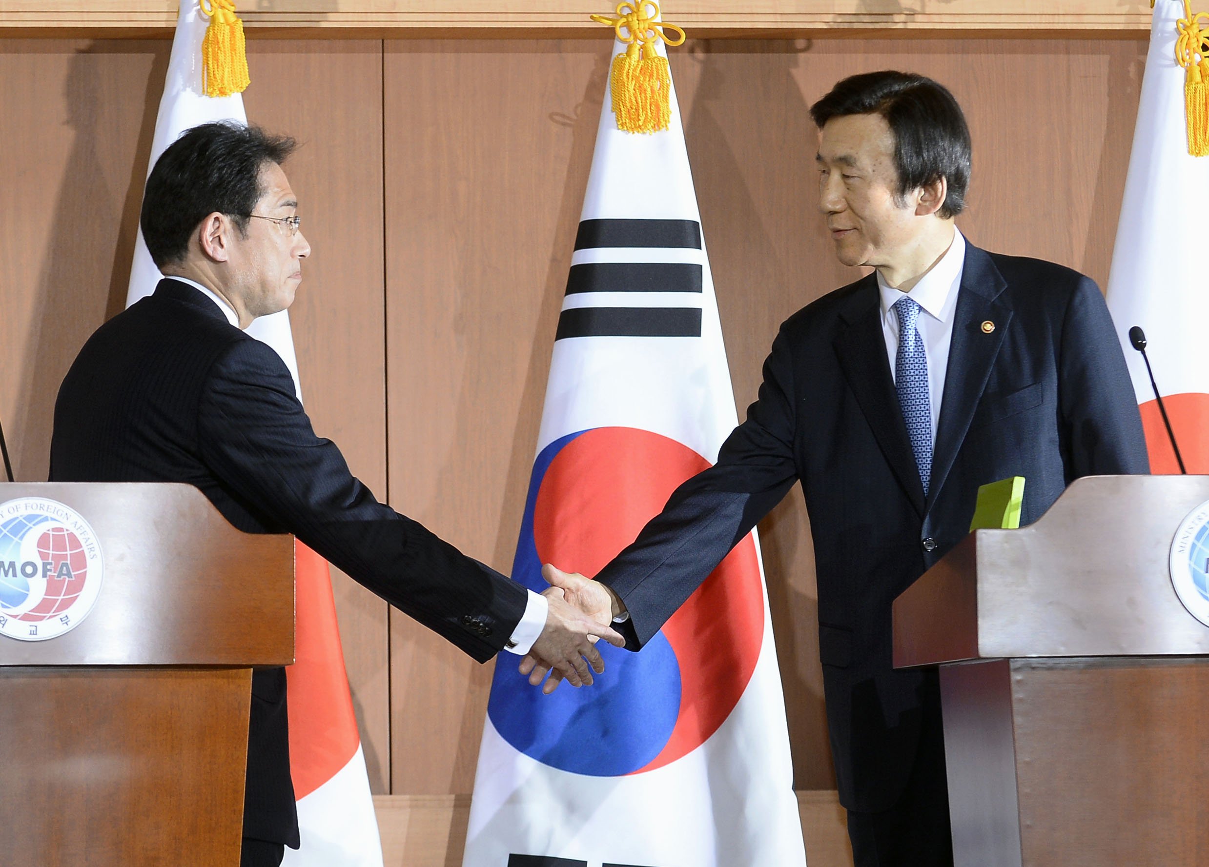 Japanese Foreign Minister Fumio Kishida (L) and his South Korean counterpart Yun Byung Se shake hands after a joint press conference at the South Korean Foreign Ministry in Seoul on Dec. 28, 2015. The two countries agreed on a set of measures the same day to bring a "final and irreversible solution" to the issue of women who were forced to work in Japan's wartime military brothels. (Kyodo) ==Kyodo