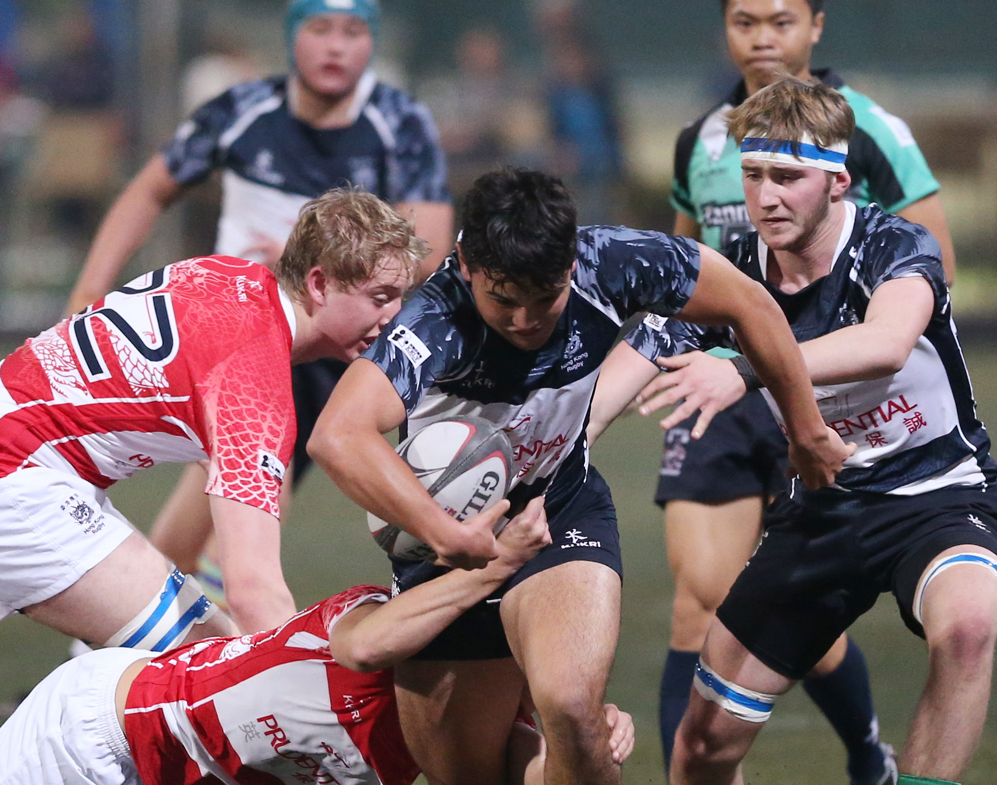 Hong Kong Dragons’ Zak Baldwin (left, in red) goes in to tackle Sam Walsh of the Overseas Lions during Friday's U19 Boys match in the New Year's Day Youth Tournament. Photo: KY Cheng/SCMP