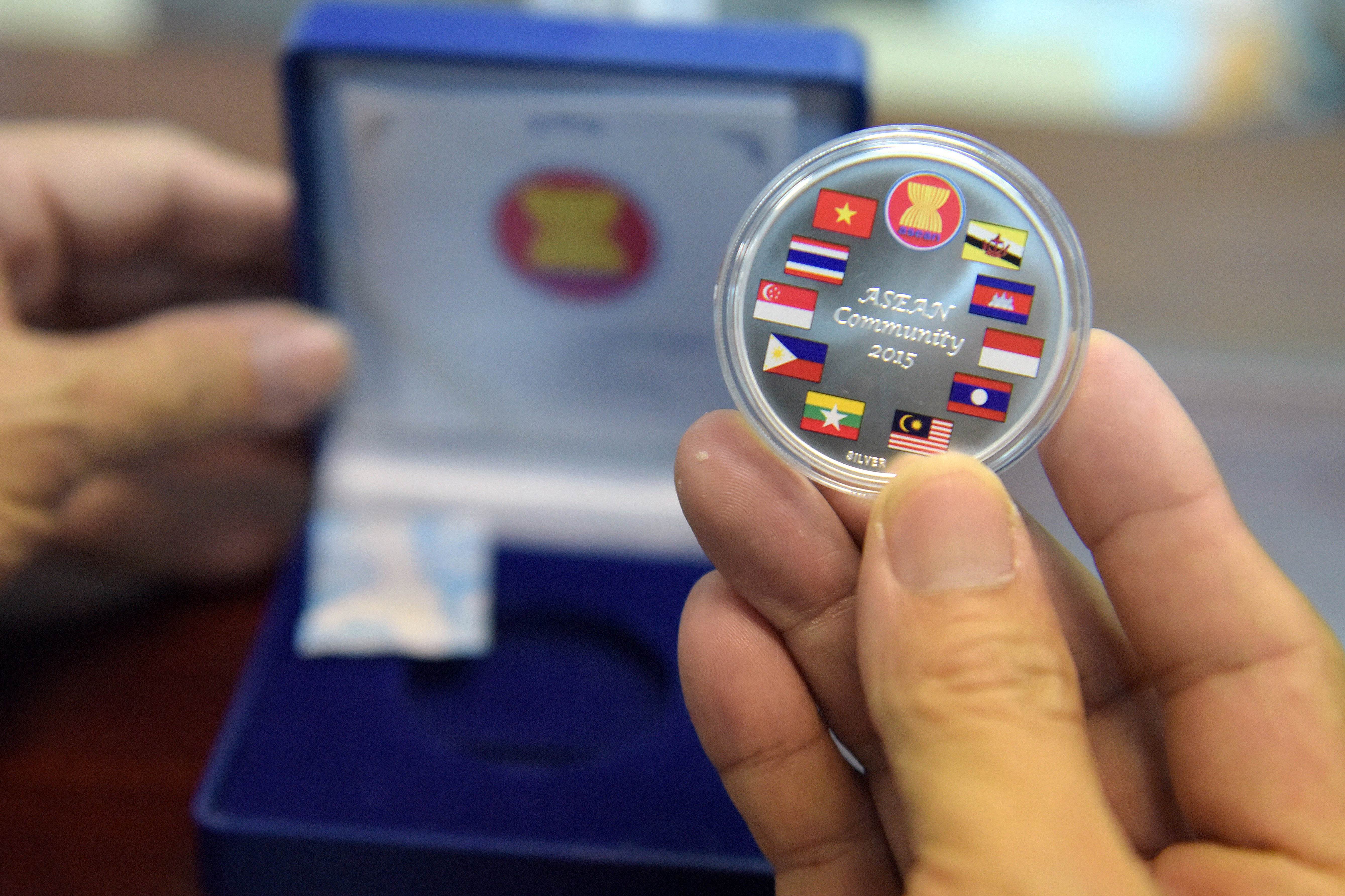 A commemorative coin with flags of ASEAN member countries is seen at the National Bank of Cambodia on December 25, 2015. The National Bank of Cambodia began the sale of silver souvenir coins bearing flags of Association of Southeast Asian Nations (ASEAN) to celebrate ASEAN community 2015 and ASEAN Economy Community (AEC) in 2016. AFP PHOTO / TANG CHHIN SOTHY