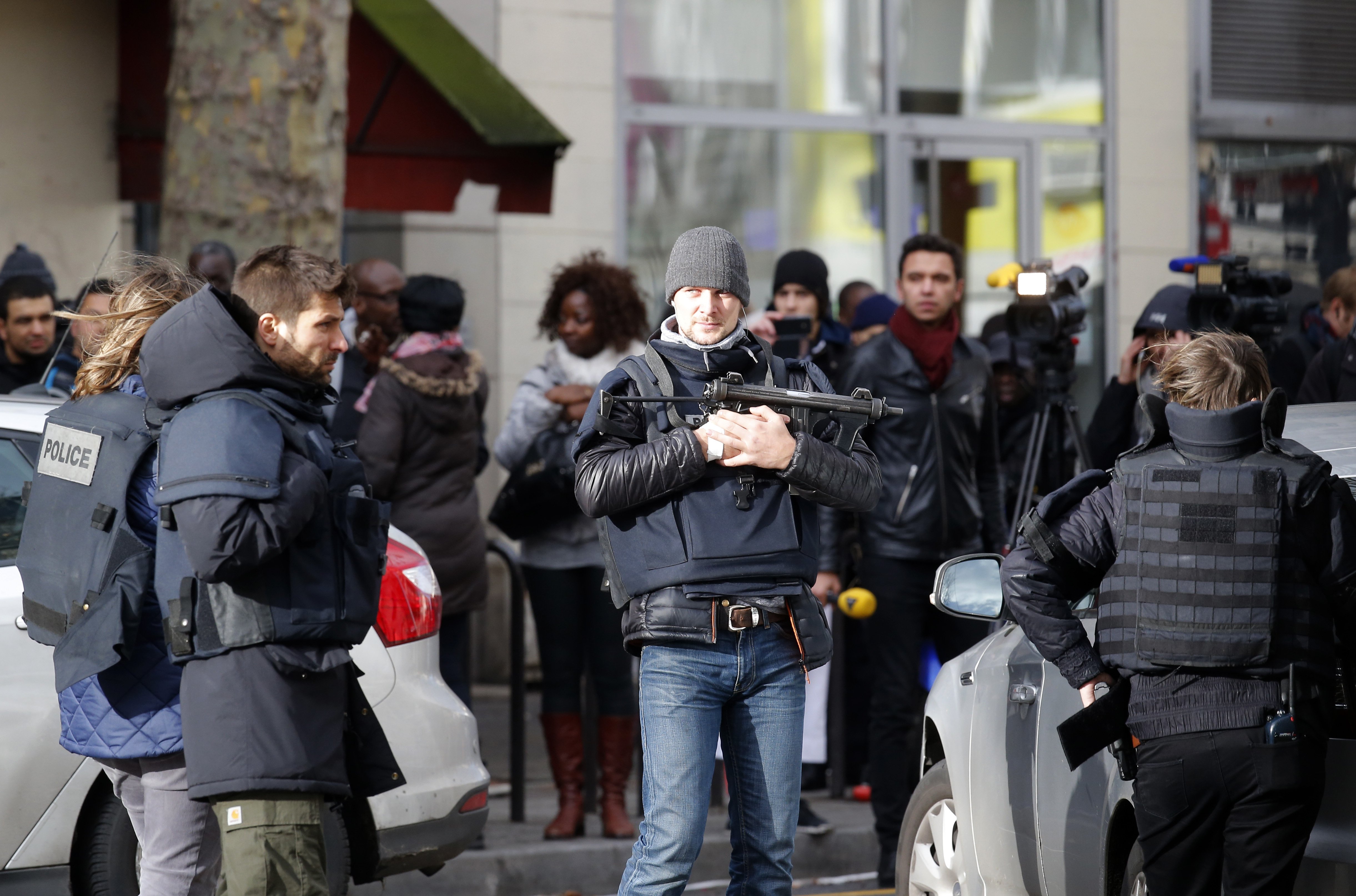 Police officers secure the area after a fatal shooting took place at a police station in Paris, Thursday, Jan. 7, 2016. Officers shot and killed a knife-wielding man wearing a fake explosive vest at a police station in northern Paris on Thursday, French officials said, a year to the day after an attack on the French satirical newspaper Charlie Hebdo launched a bloody year in the French capital. (AP Photo/Michel Euler)