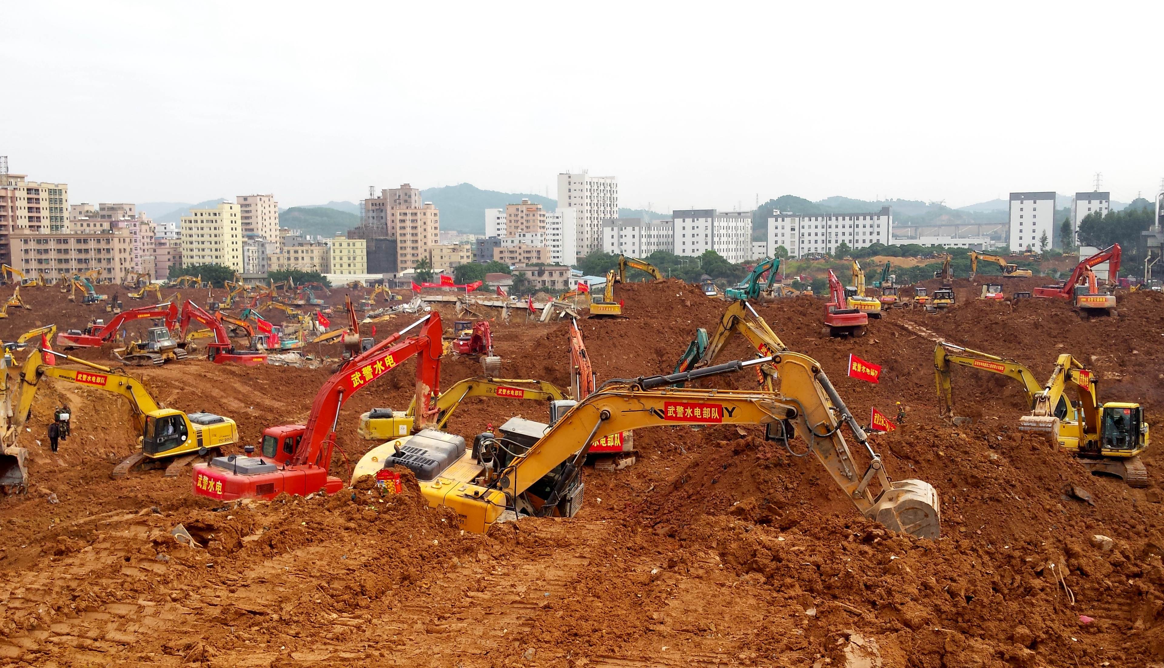 Excavators are seen working at the site of the landslide in an industrial area in Shenzhen, south China's Guangdong province on December 28, 2015. The head of an urban enforcement agency in the Chinese district where a huge landslide left scores of people missing has killed himself, authorities said on December 28. Xu Yuan'an, head of the City Urban Administrative and Law Enforcement Bureau for Shenzhen's Guangming New District, jumped to his death on December 27, according to a post on an official police social media account. CHINA OUT AFP PHOTO