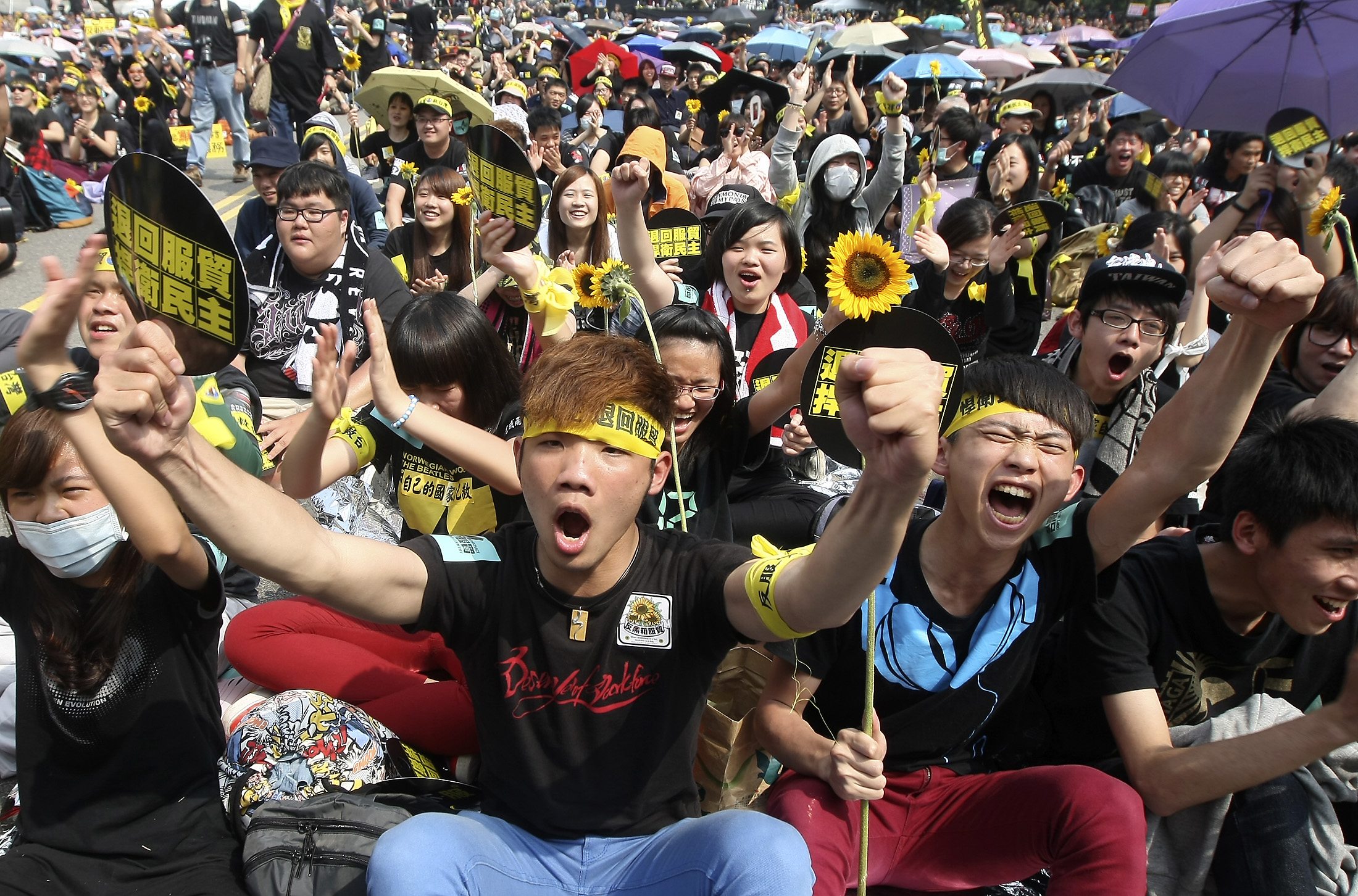 Demonstrators shout slogans in front of the Presidential Office in Taipei March 30, 2014. Thousands of demonstrators marched the streets to protest against the controversial trade pact with mainland China. The Chinese characters read, "Defend democracy; Reject the trade pact." REUTERS/Toby Chang (TAIWAN - Tags: POLITICS CIVIL UNREST)