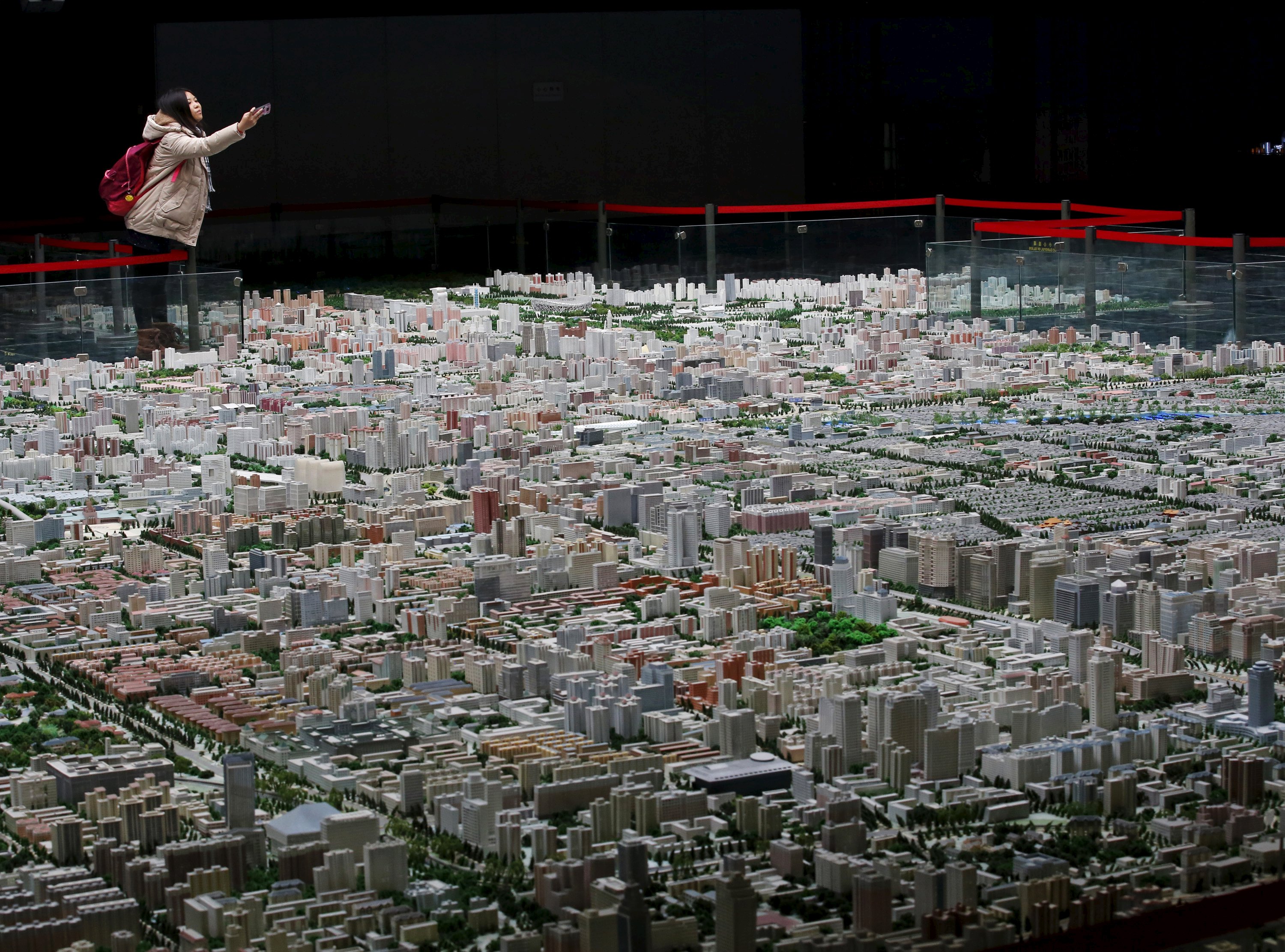 A visitor takes pictures of a model of Beijing's downtown at the Beijing Planning Exhibition Hall, a museum showcasing the achievement of Beijing urban planning construction, in Beijing in this November 5, 2013 file photo. For foreign investors, Beijing's decision to make it easier for them to invest in Chinese real estate is on the right track but has come at the wrong time. China announced last week that it was removing a series of cumbersome pieces of regulation on foreign property investment introduced in 2006 that have hindered investors from accessing what was once viewed as one of the most attractive real estate markets in the world. REUTERS/Kim Kyung-Hoon/Files
