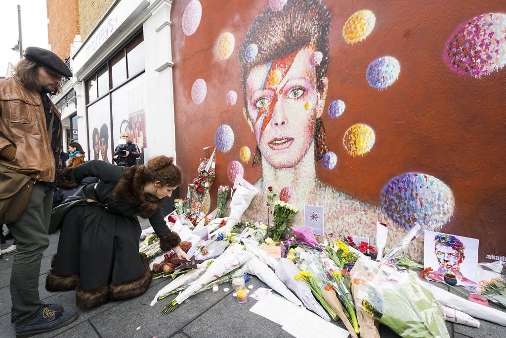 (160111) -- LONDON, Jan. 11, 2016 (Xinhua) -- Fans pay their respects with flowers and messages at a David Bowie mural in Brixton, South London, Britain, on Jan. 11, 2016. David Bowie, the iconic British singer-songwriter died on Sunday, just two days after his 69th birthday, his family announced Monday in a brief statement. (Xinhua/Ray Tang)