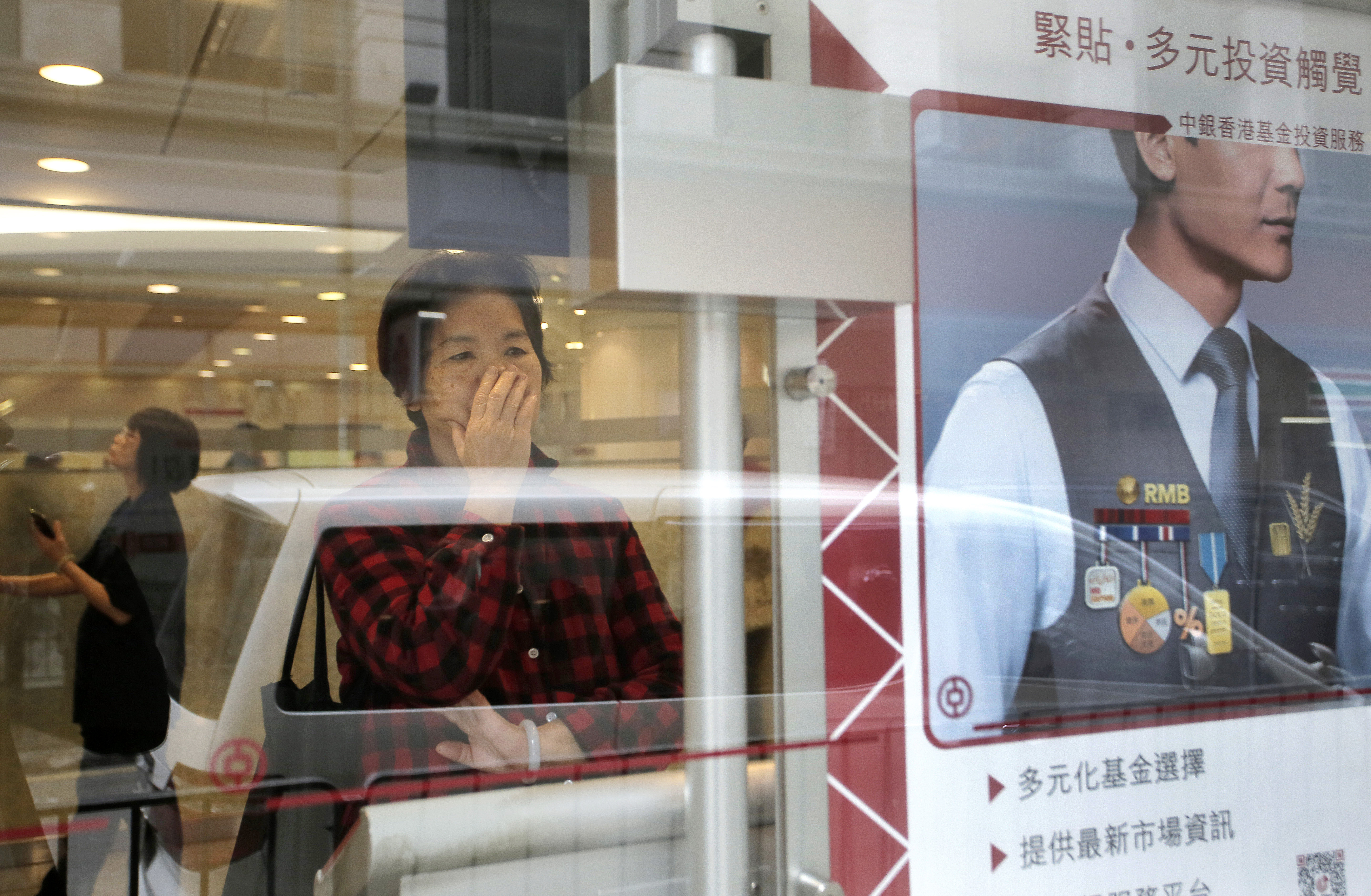 A woman looks at a computer screen showing the Hong Kong share indexes at a local bank in Hong Kong, Thursday, Jan. 7, 2016. Chinese stocks nosedived Thursday, triggering their second daylong trading halt this week and sending share markets, Asian currencies and oil prices lower as investor jitters rippled across the globe. (AP Photo/Vincent Yu)