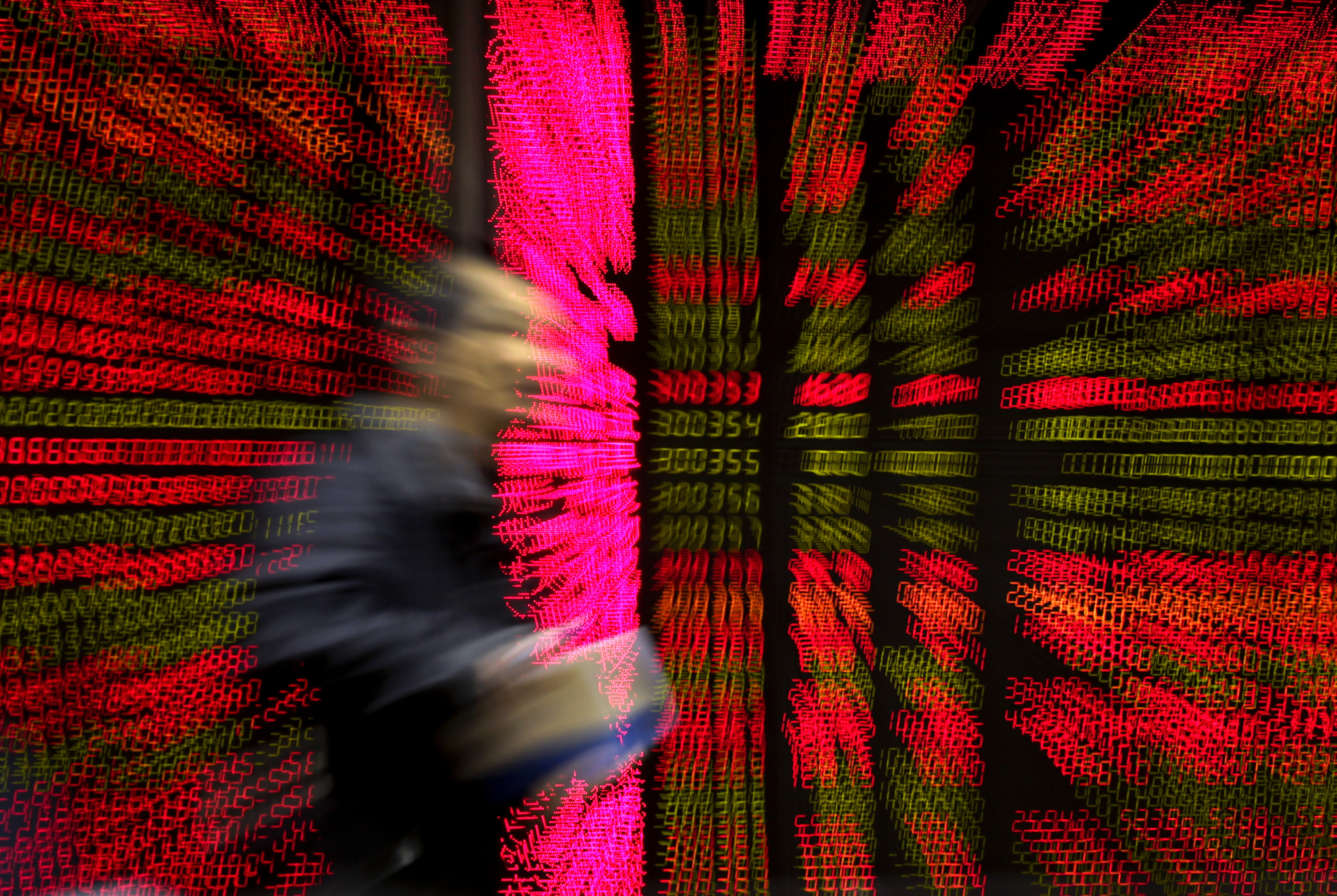 A man walks past an electronic board displaying stock prices at a brokerage house in Beijing, Tuesday, Jan. 12, 2016. Chinese stocks seesawed Tuesday as worries lingered over the country's financial markets and economic outlook, fueling volatility in other Asian benchmarks. (AP Photo/Andy Wong)