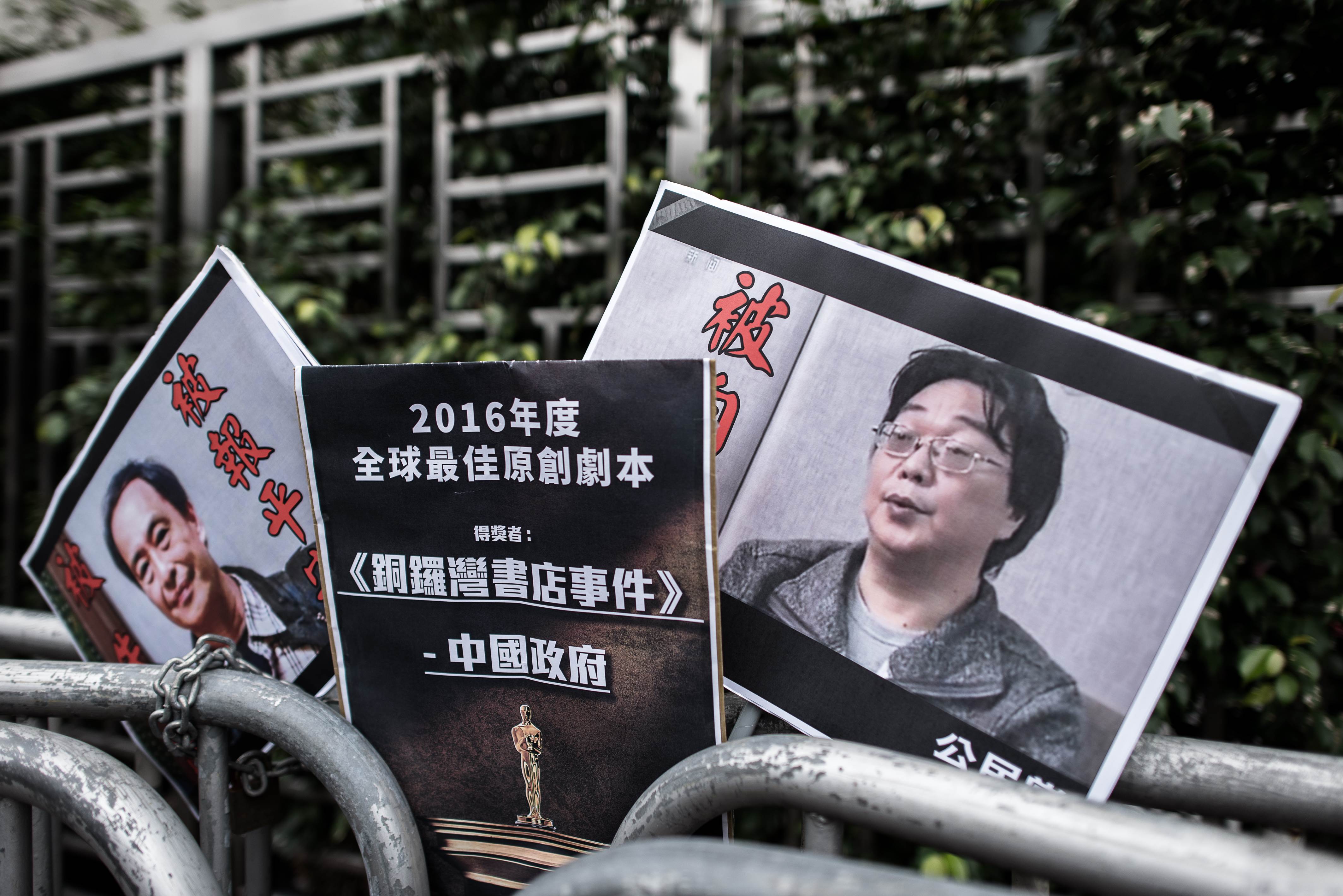 Placards showing missing bookseller Lee Bo (L) and his associate Gui Minhai (R) are seen left by members of the Civic party outside the China liaison office in Hong Kong on January 19, 2016. China has confirmed that a missing Hong Kong-based bookseller, one of five men whose disappearance fuelled fears of an erosion of the city's freedoms, is on the mainland, the city's government said. AFP PHOTO / Philippe Lopez