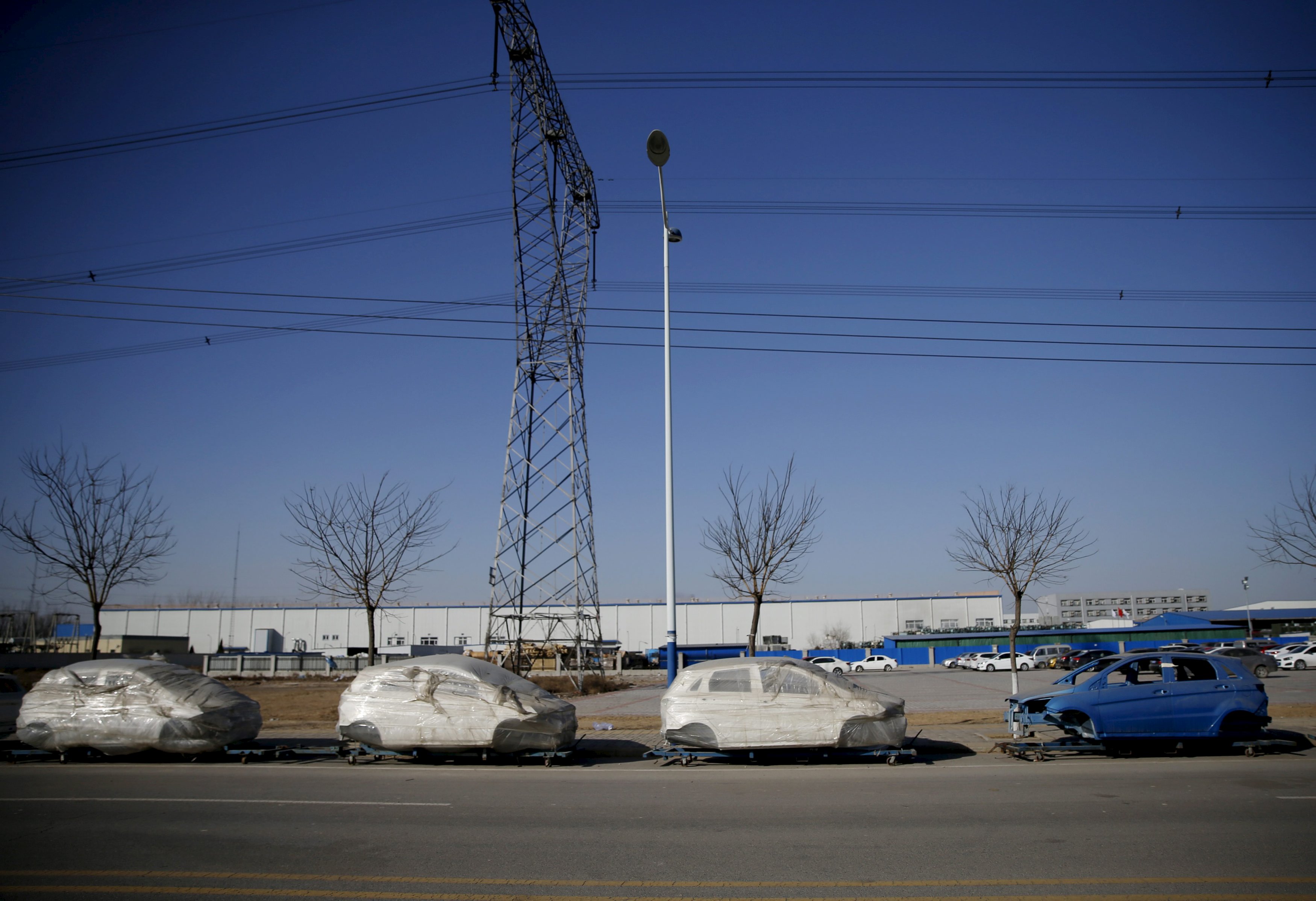 Car frames wrapped in plastics are seen placed outside a car factory at an industrial complex in Beijing, China, January 18, 2016. Picture taken January 18. REUTERS/Kim Kyung-Hoon